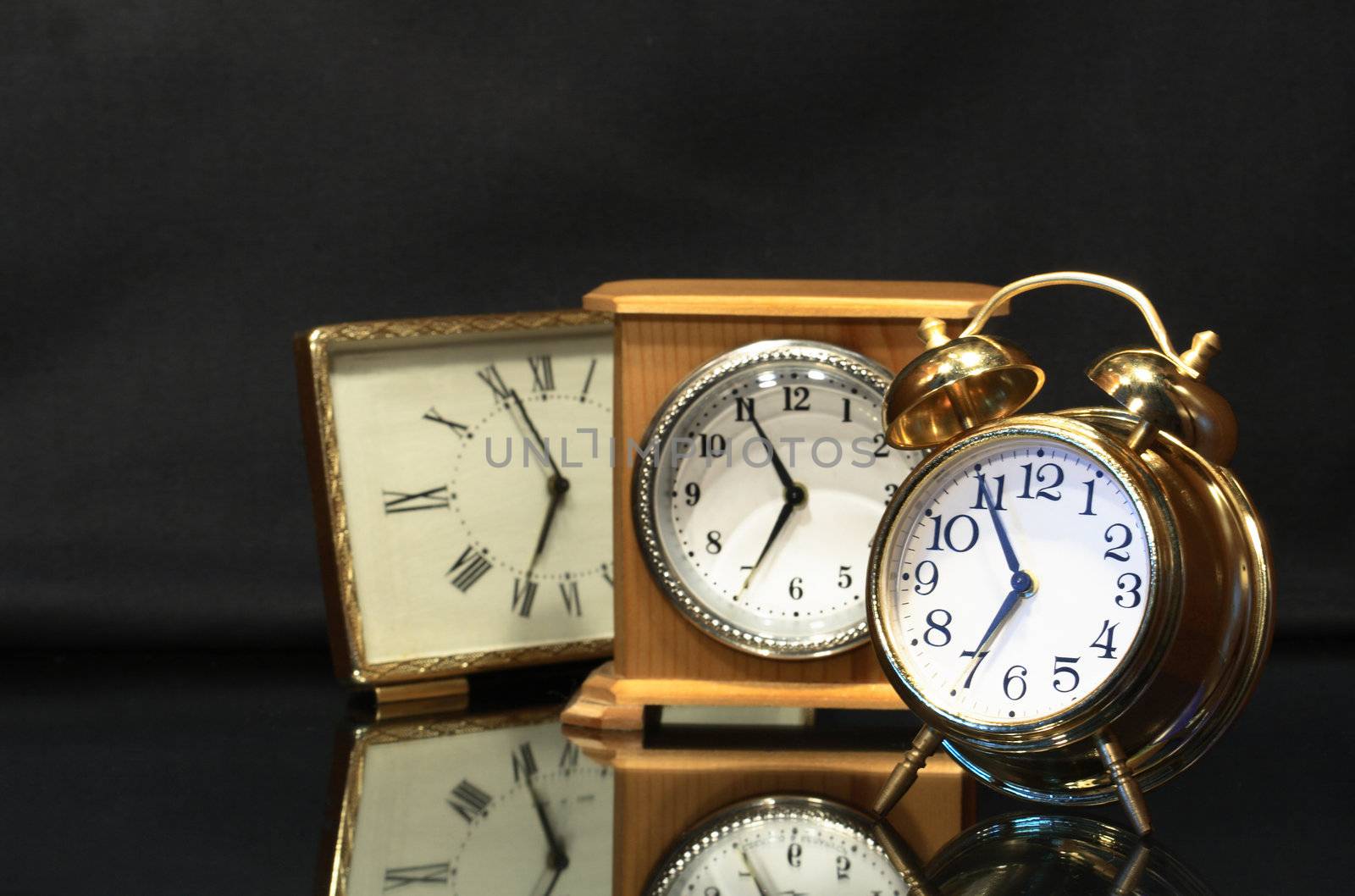 Three various alarm clocks isolated on dark background
