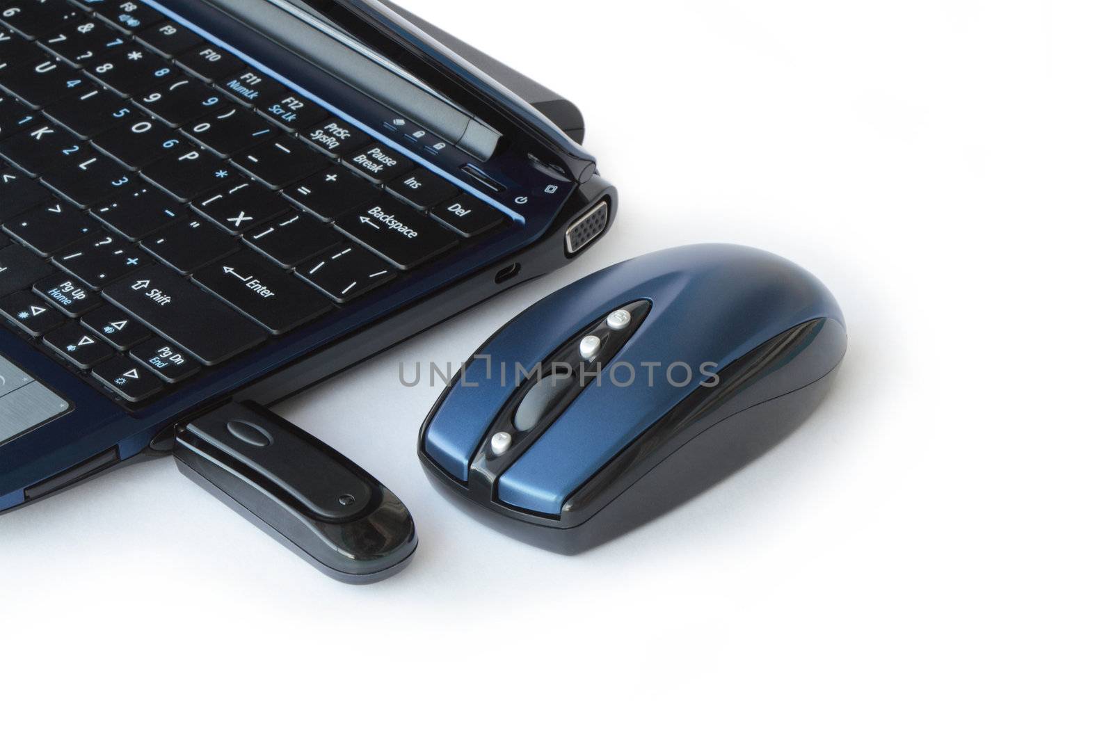 Wireless computer mouse lying near laptop isolated on white background