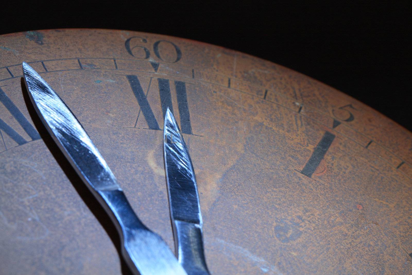 Closeup of old rusty bronze clock dial. Clock hands made from sharpen steel scalpels