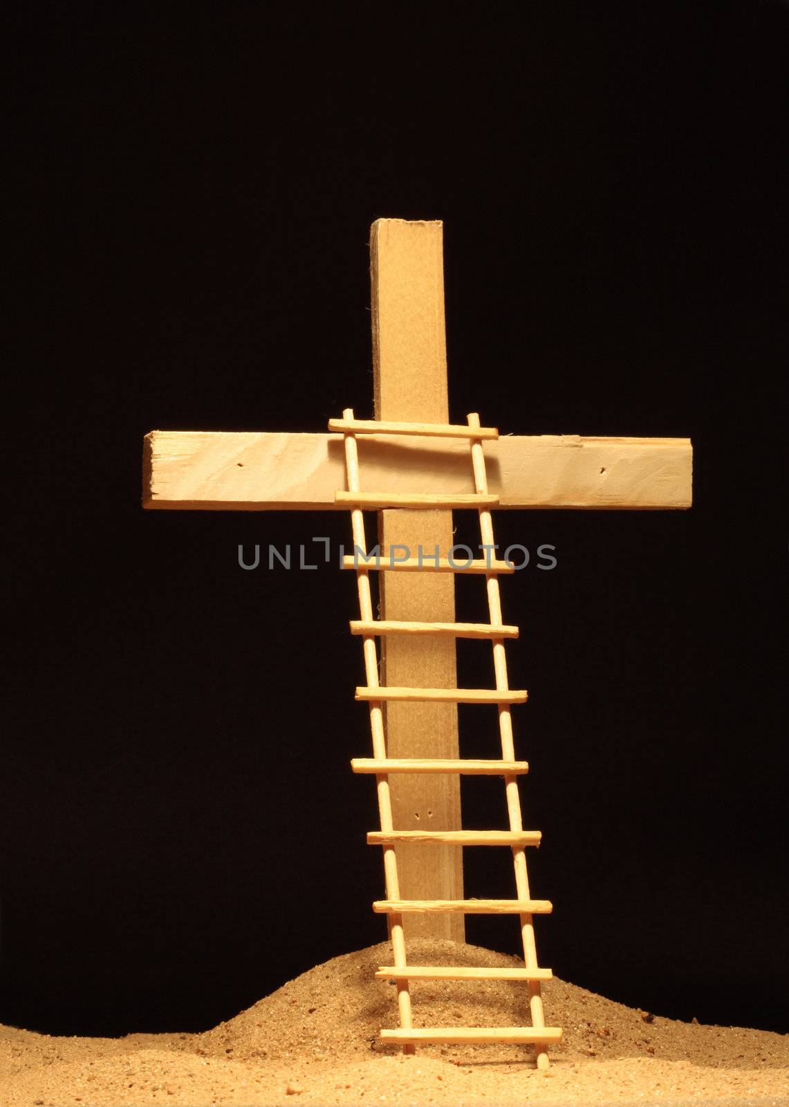 Ladder standing near wooden cross on dark background