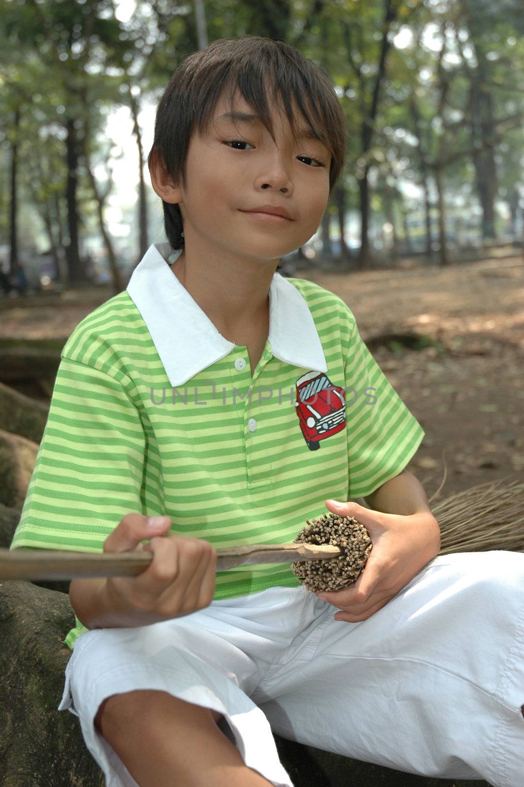 photograph of little asian boy sit down in park