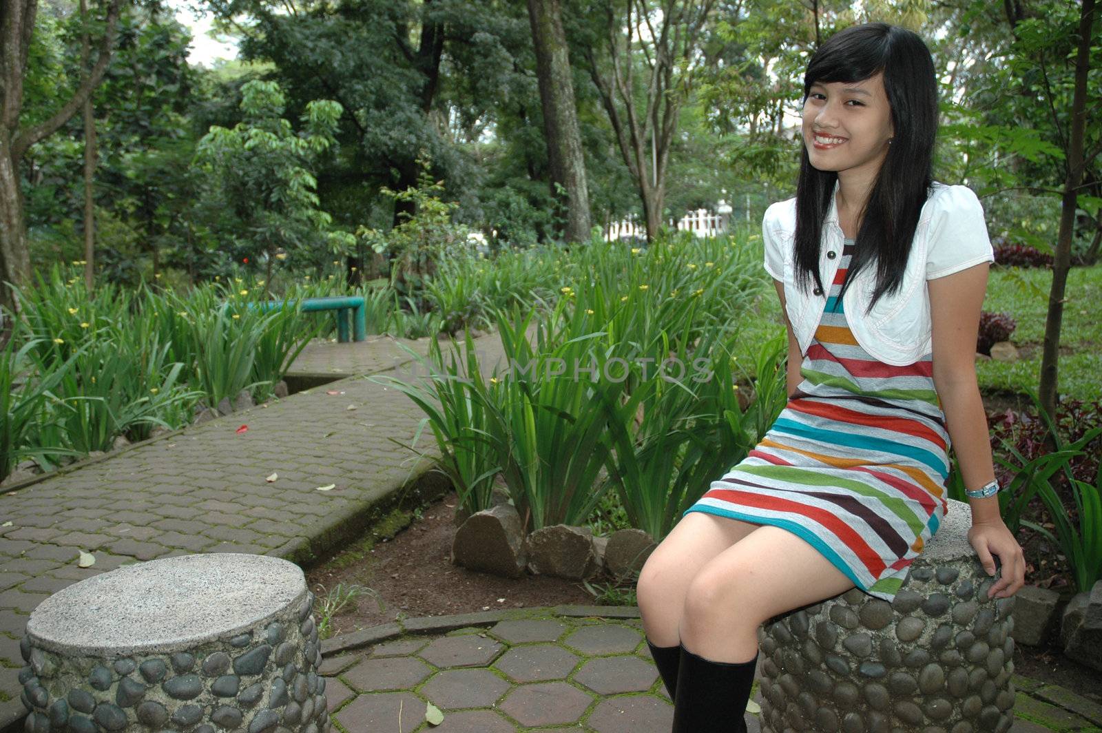 young asian lady sit down in park