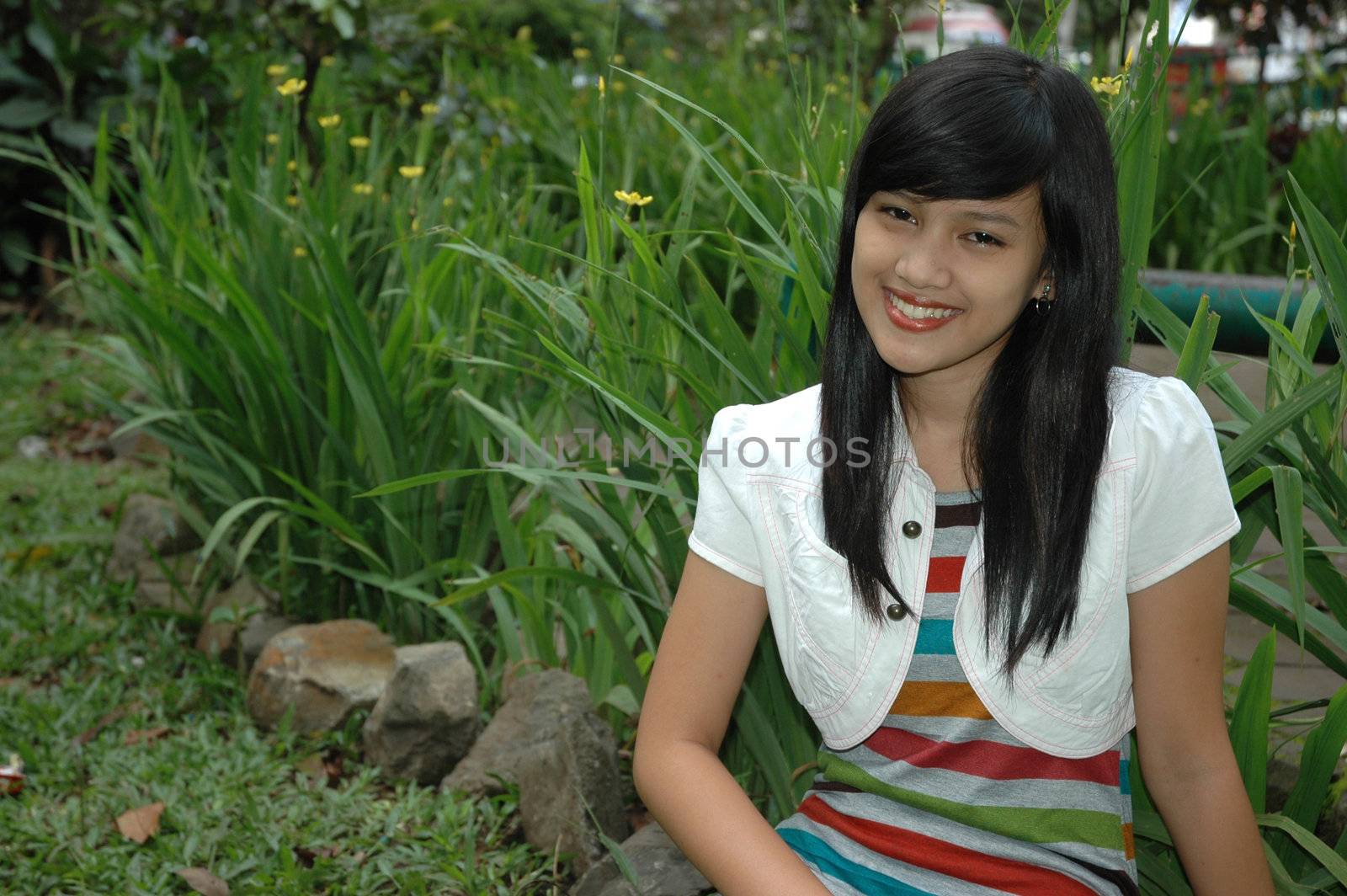 young asian lady sit down in park