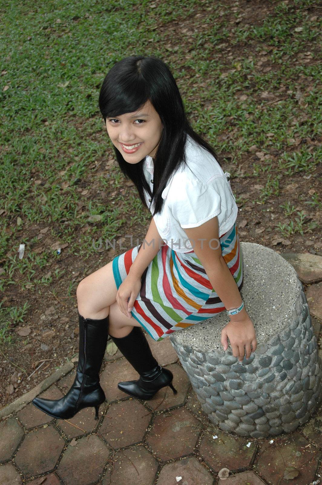 young asian lady sit down in park

