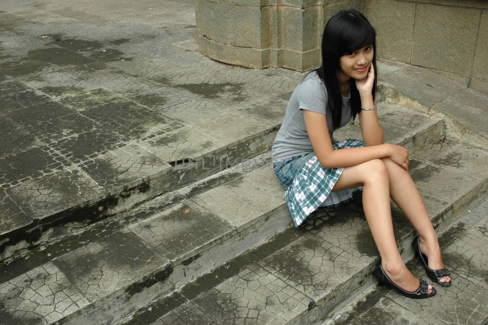 young asian lady sit down in park