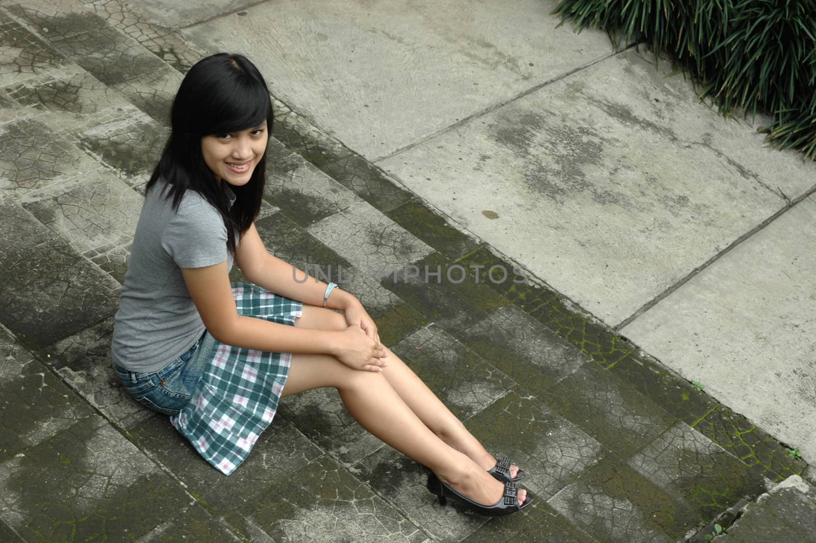 young asian lady sit down in park