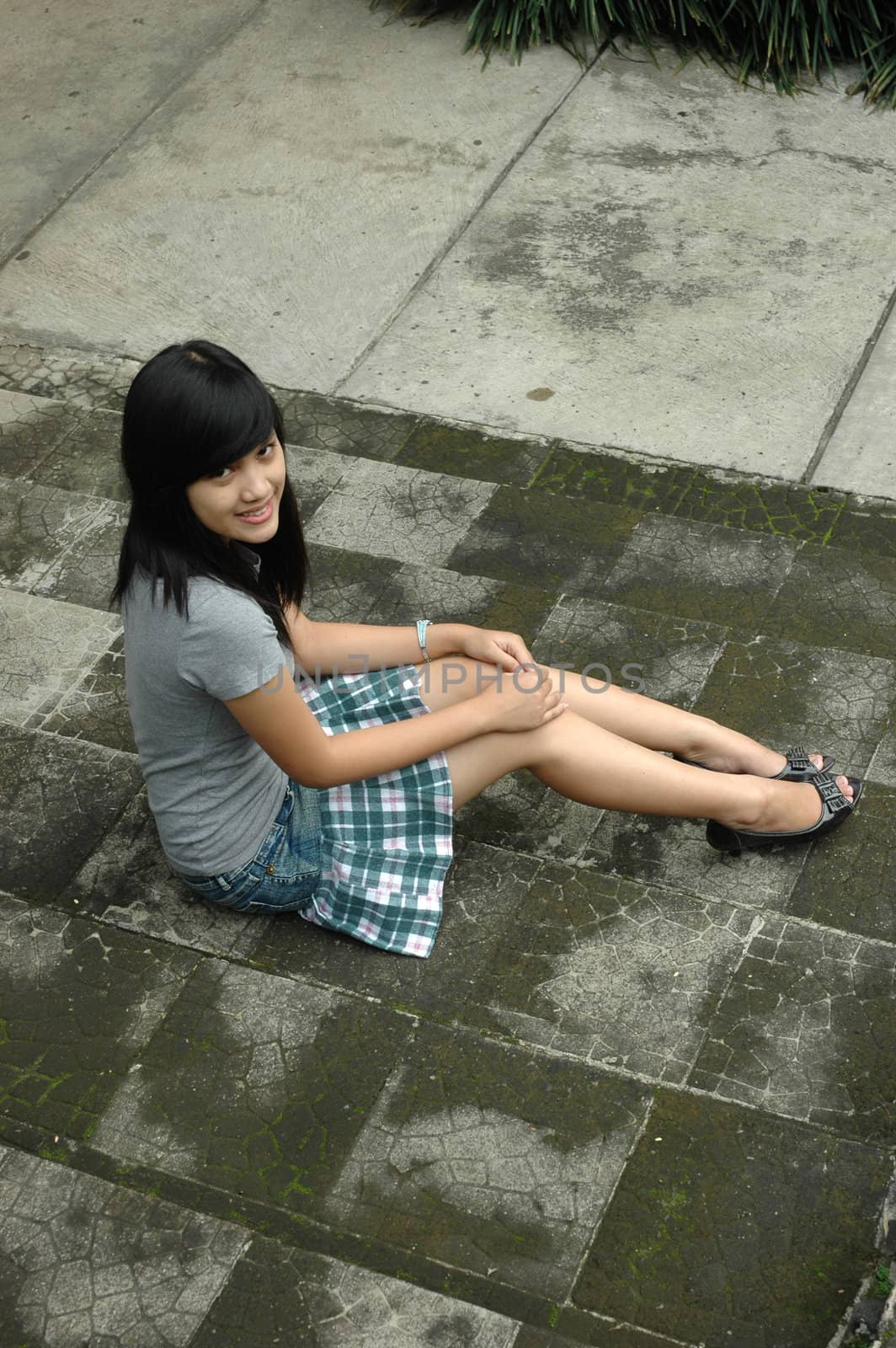 young asian lady sit down in park