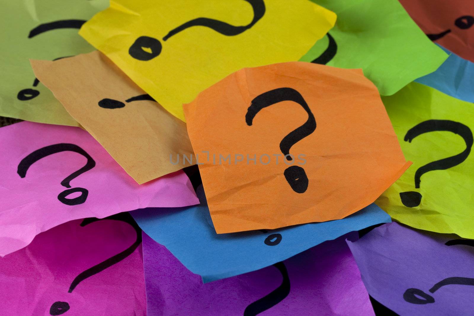 questions, decision making or uncertainty concept - a pile of colorful crumpled sticky notes with question marks