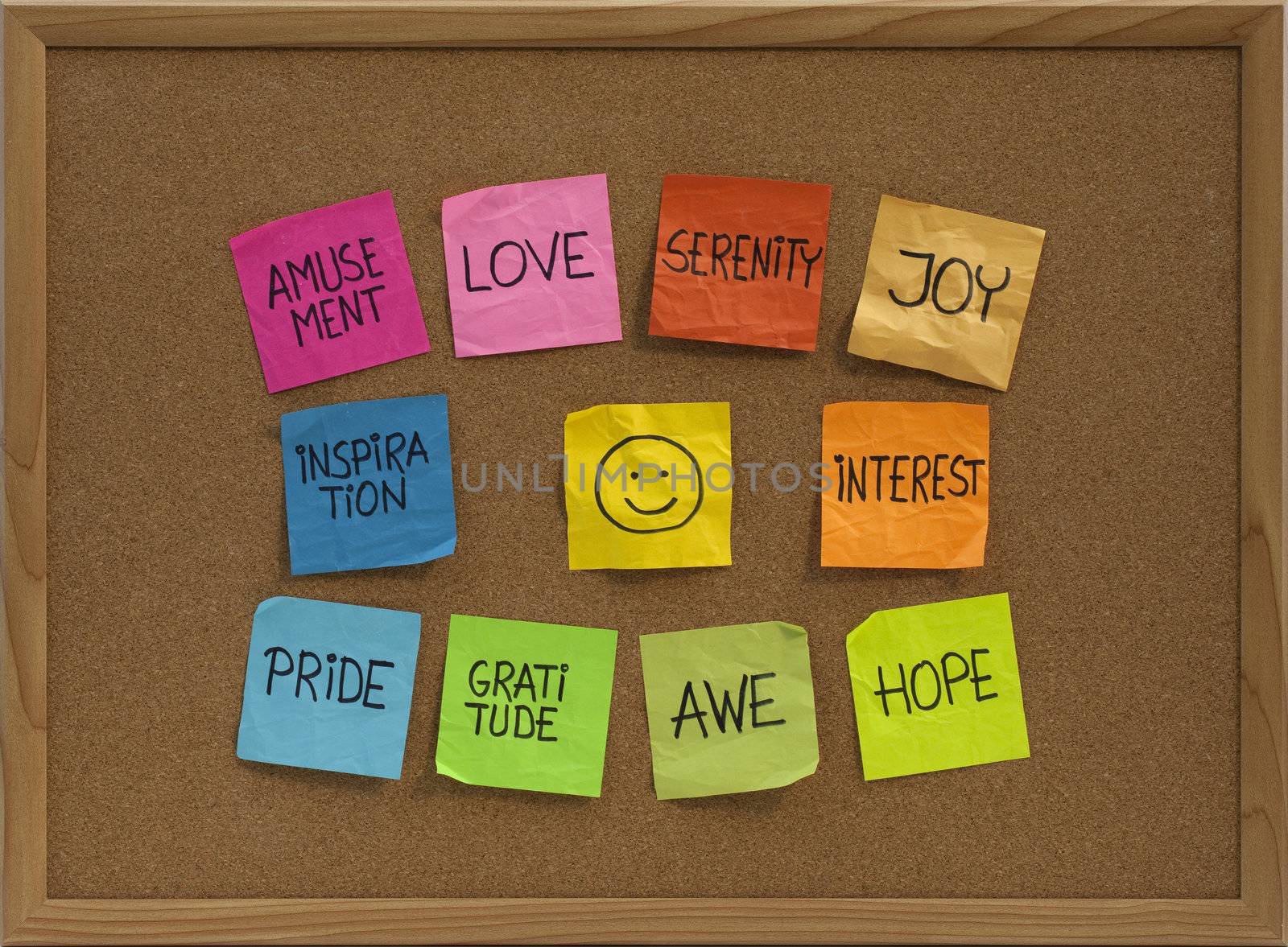 positive emotions concept - color sticky notes around smiley on cork bulletin board