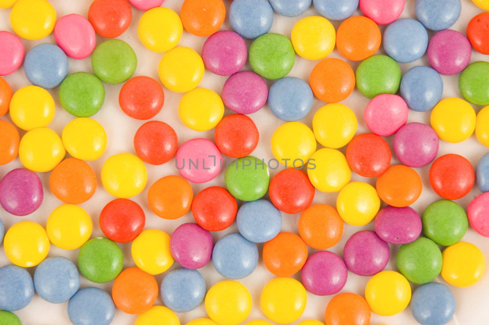 Lots of colorful smarties on white 