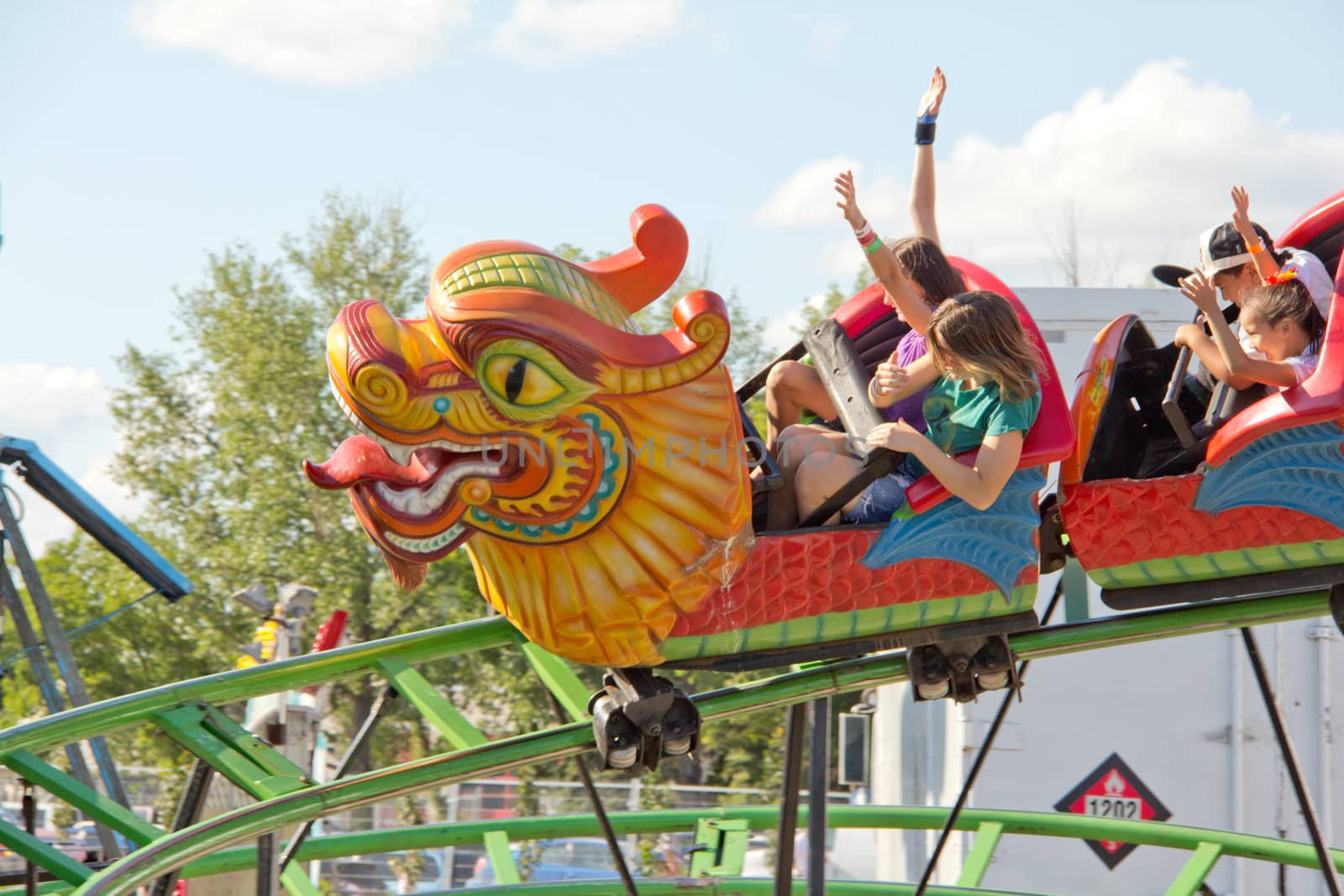 Kids riding the dragon roller coaster as it zooms on its track