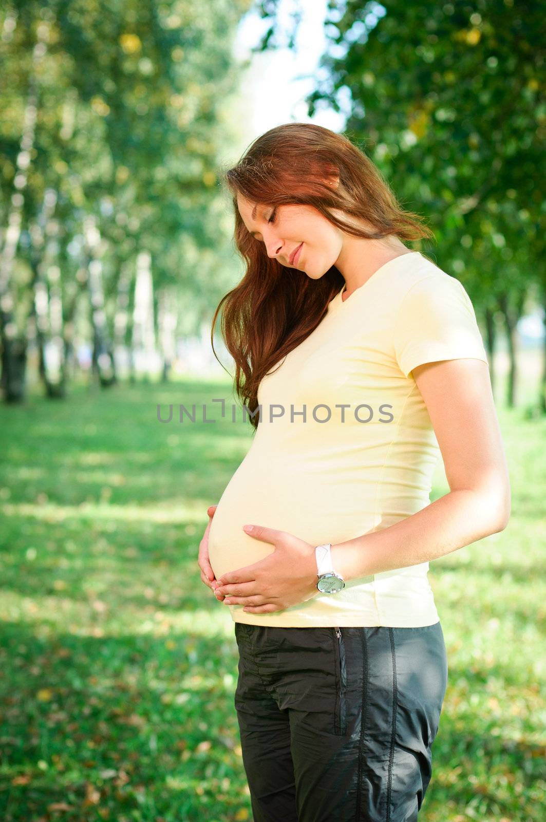 Beautiful pregnant woman relaxing in the park