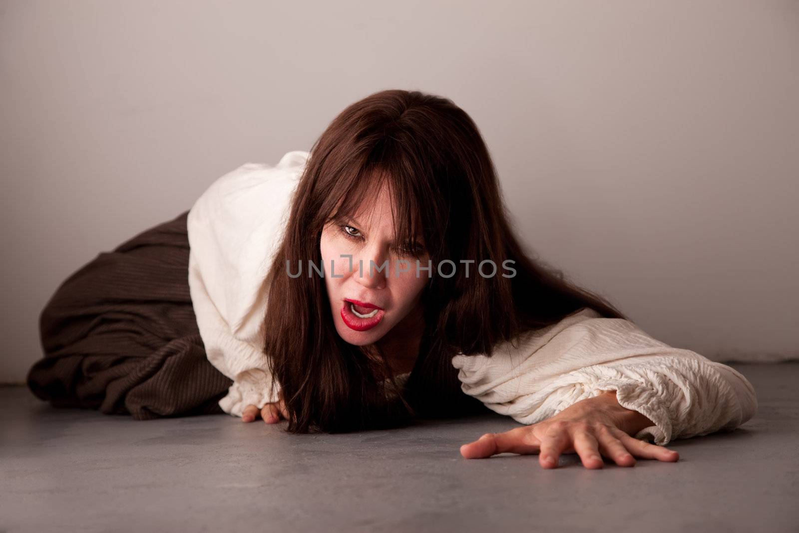 Beautiful female horror movie style victim crawling on the floor
