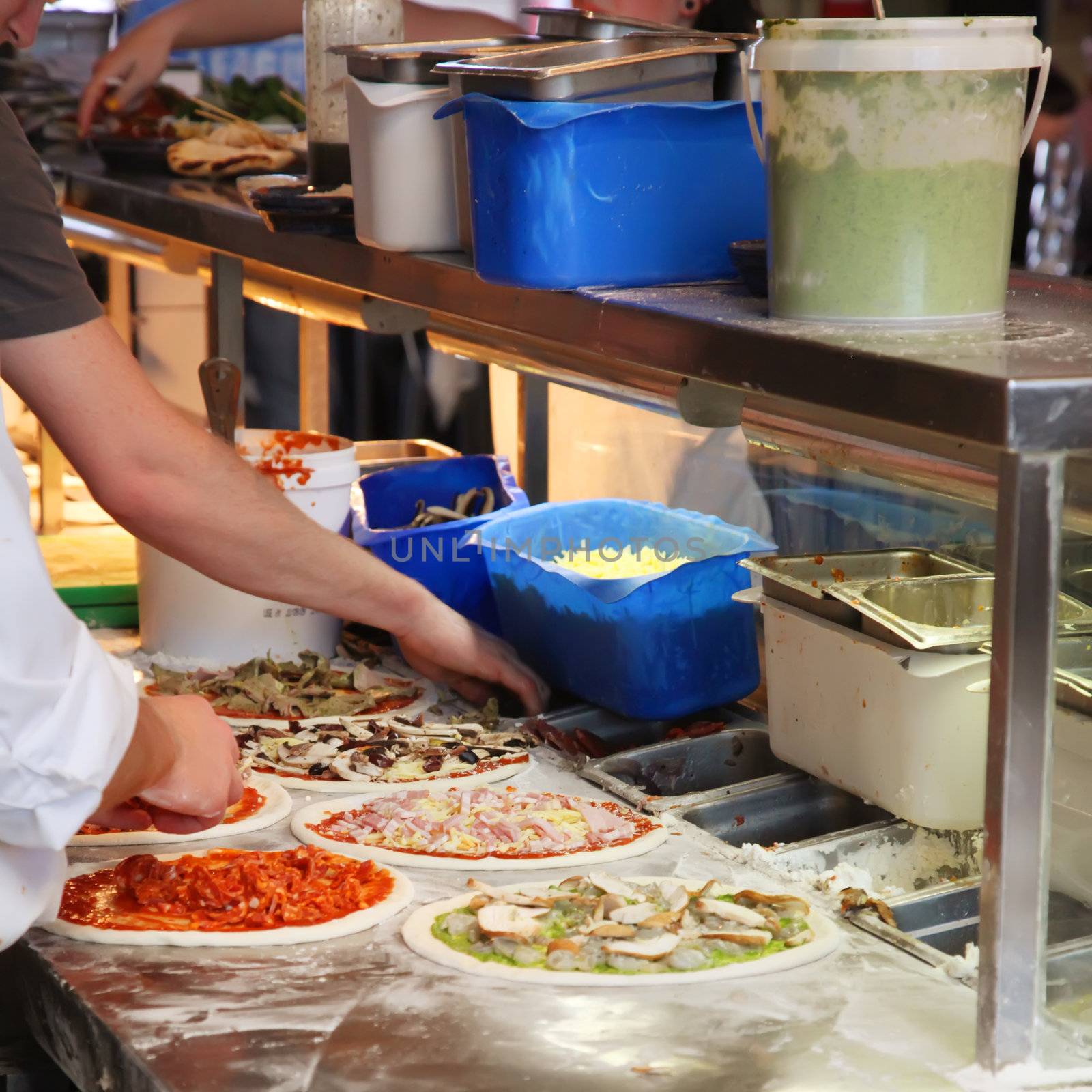 Chef Making Assorted Pizzas in a Restaurant