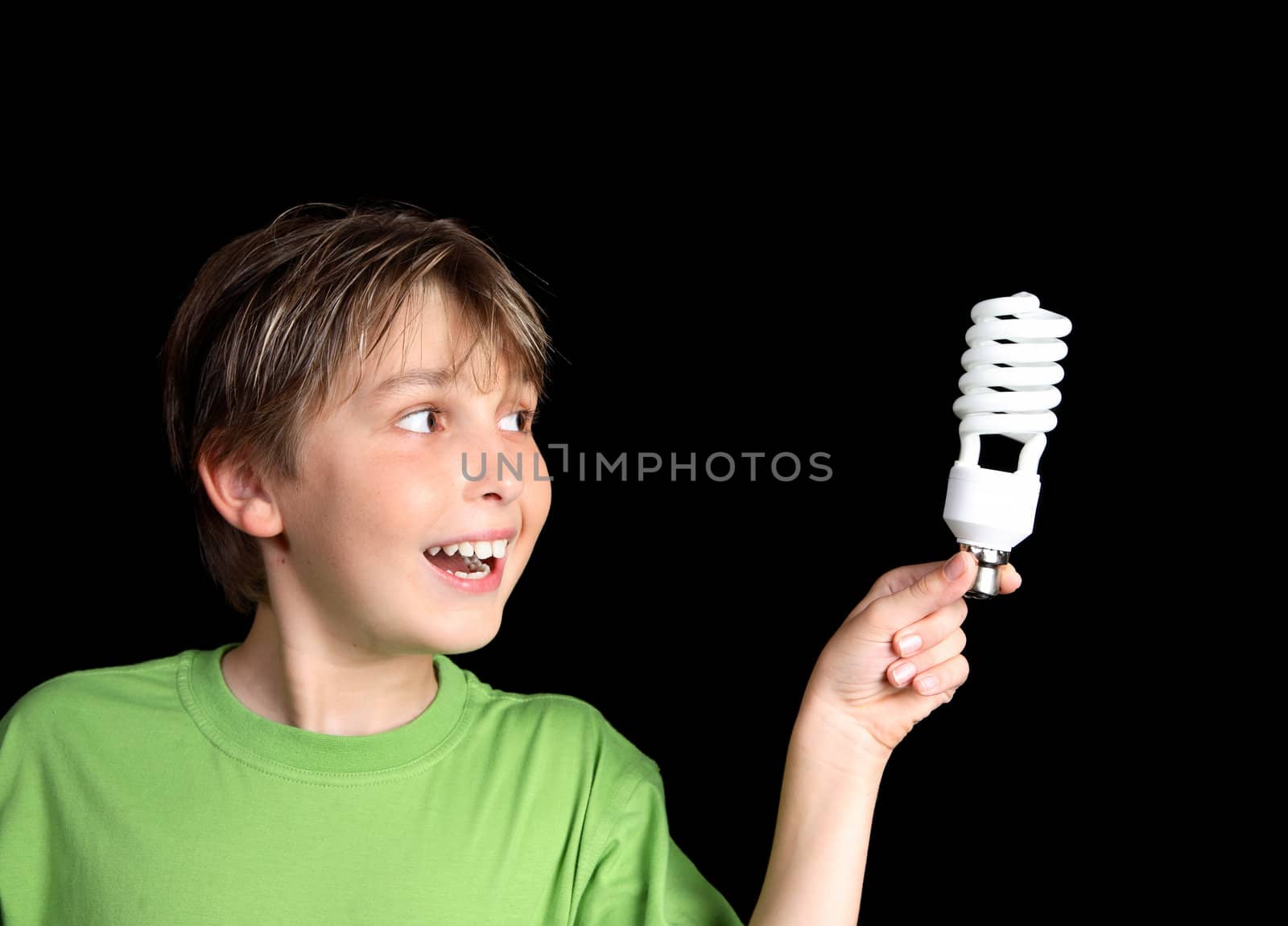Horizontal closeup of a boy holding an energy efficient light globe and smiling inspirationally.