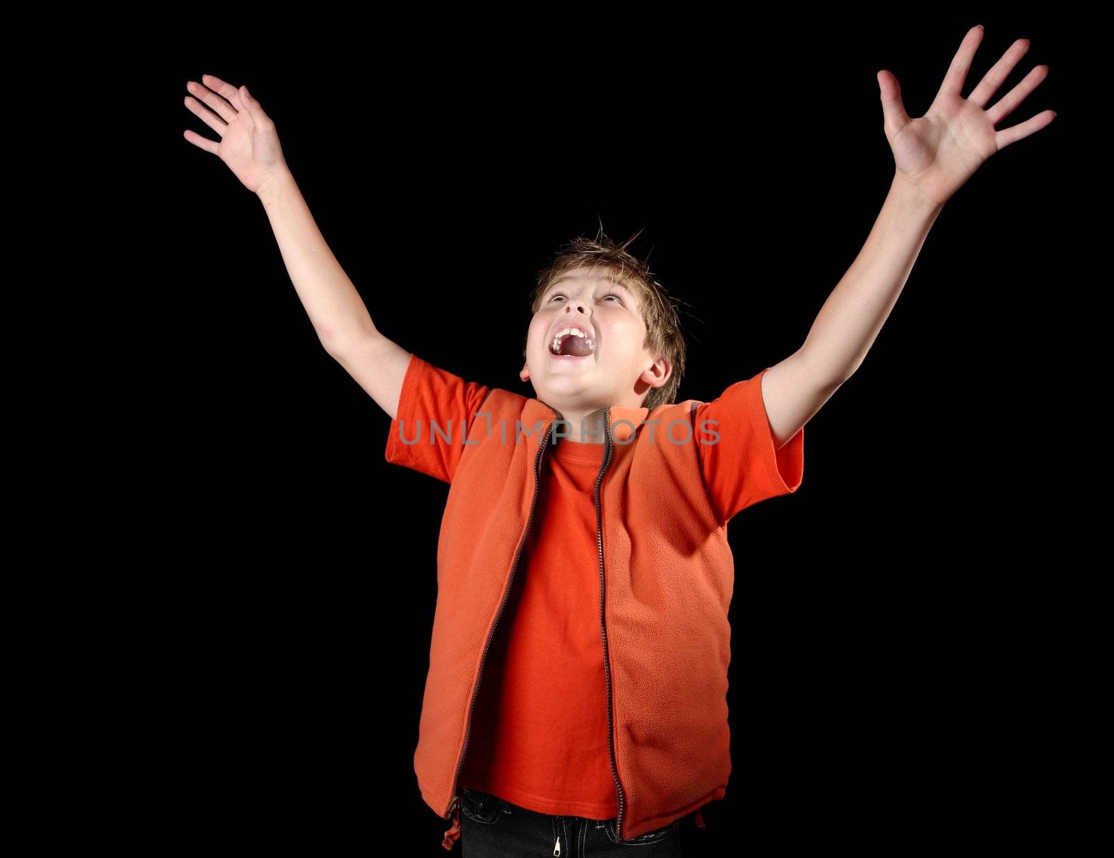 A child raises his hands in praise