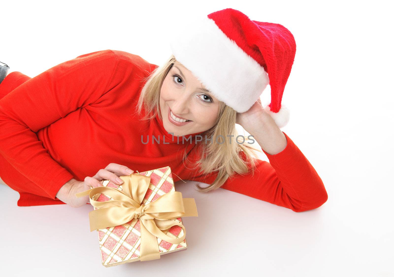 Smiling girl lying on the floor casually and holding a Christmas present.