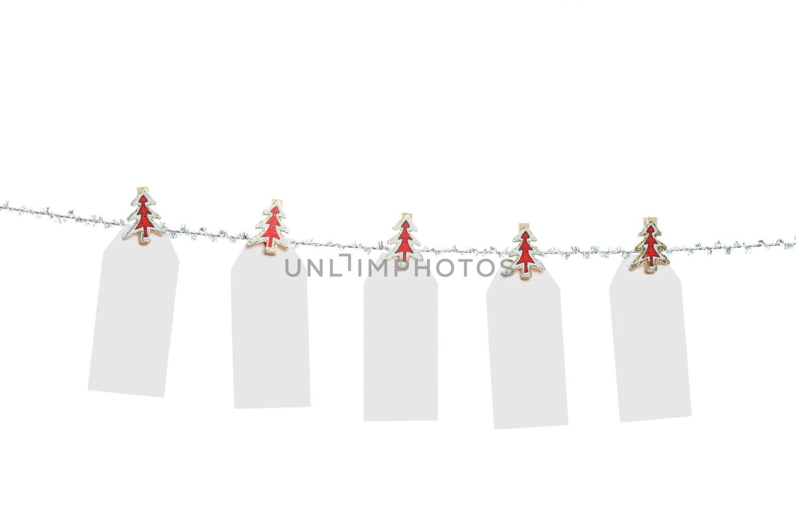 Five blank Christmas tags pegged to a silver tinsel string  line - ready for your own text or message.