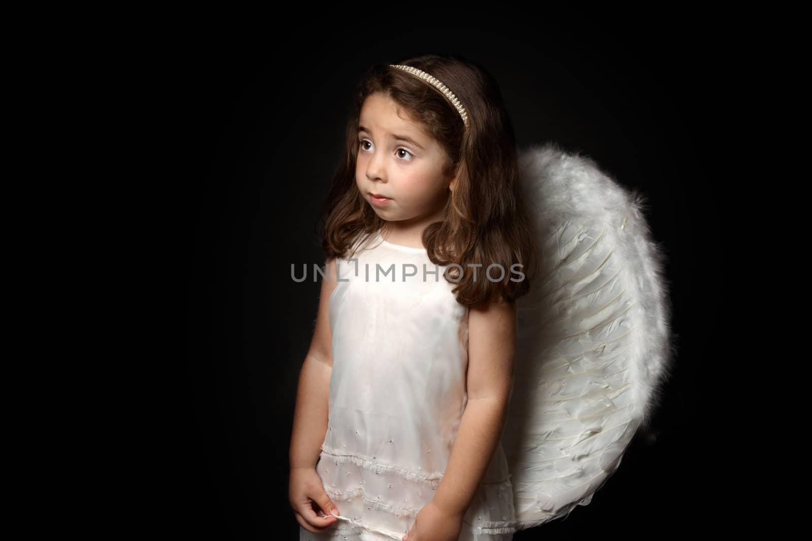 Angelic little girl looking sideways with space for copy.