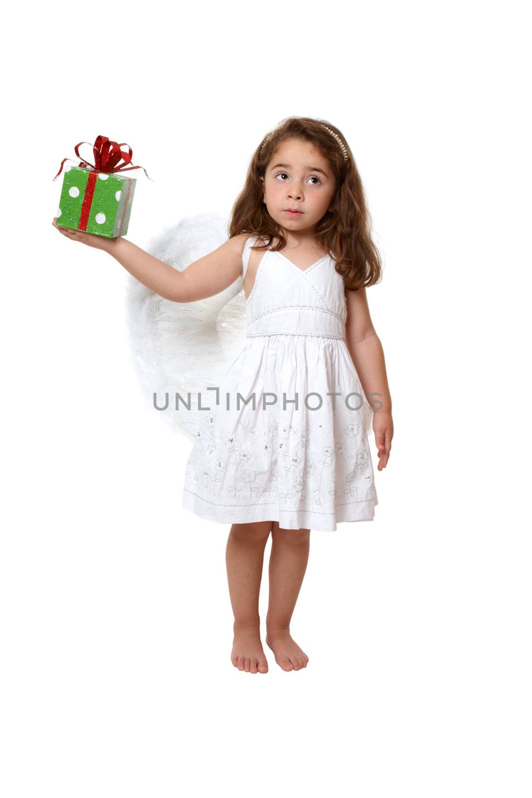Little girl in feathered angel wings and white dress holds a present or gift