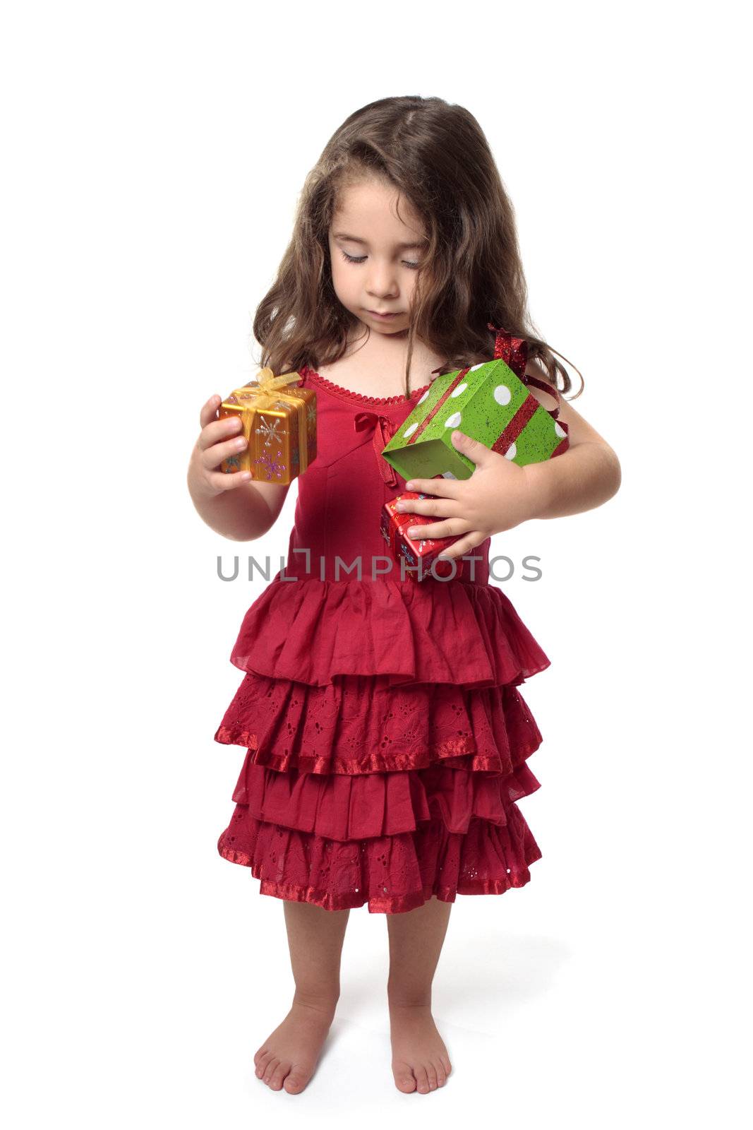 Young girl in pretty red dress holding an armful of red, green and gold gifts.