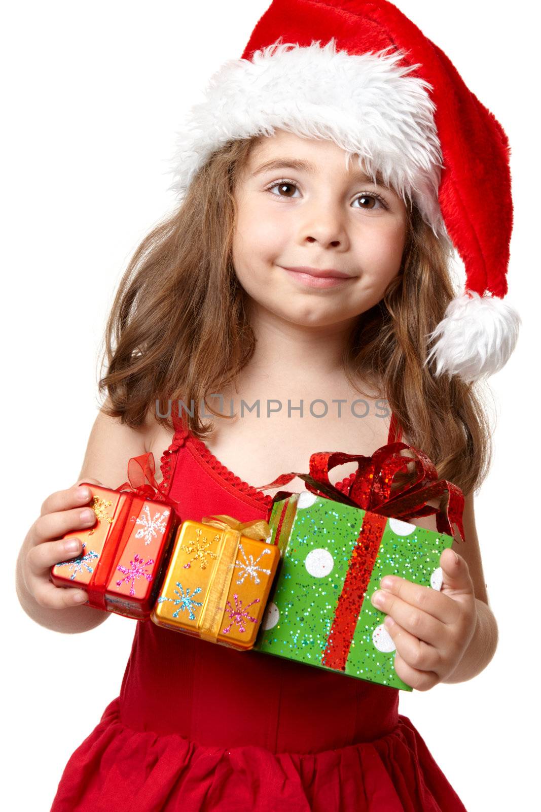 Young child in red dress and red santa hat holding Christmas presents