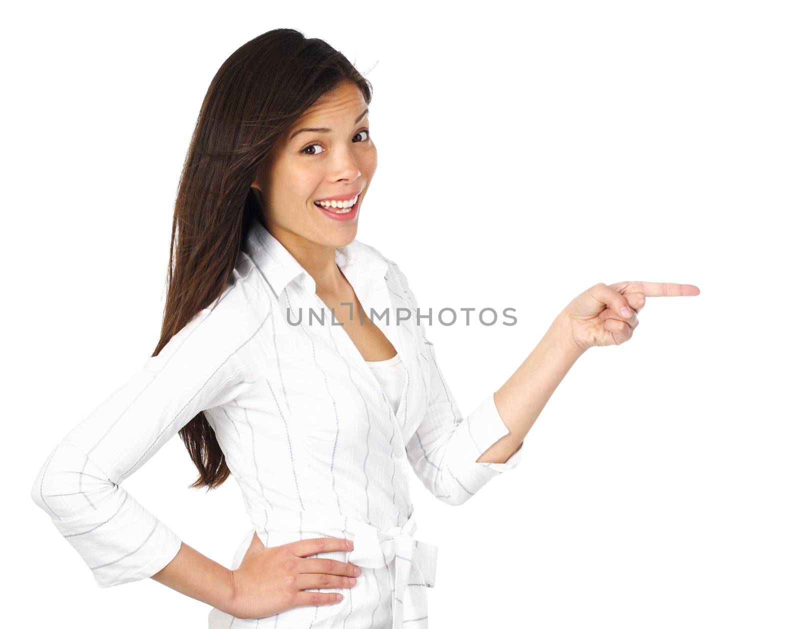 Isolated excited and surprised woman pointing at your product, looking at the camera. Isolated on white background. Beautiful mixed asian / caucasian model.