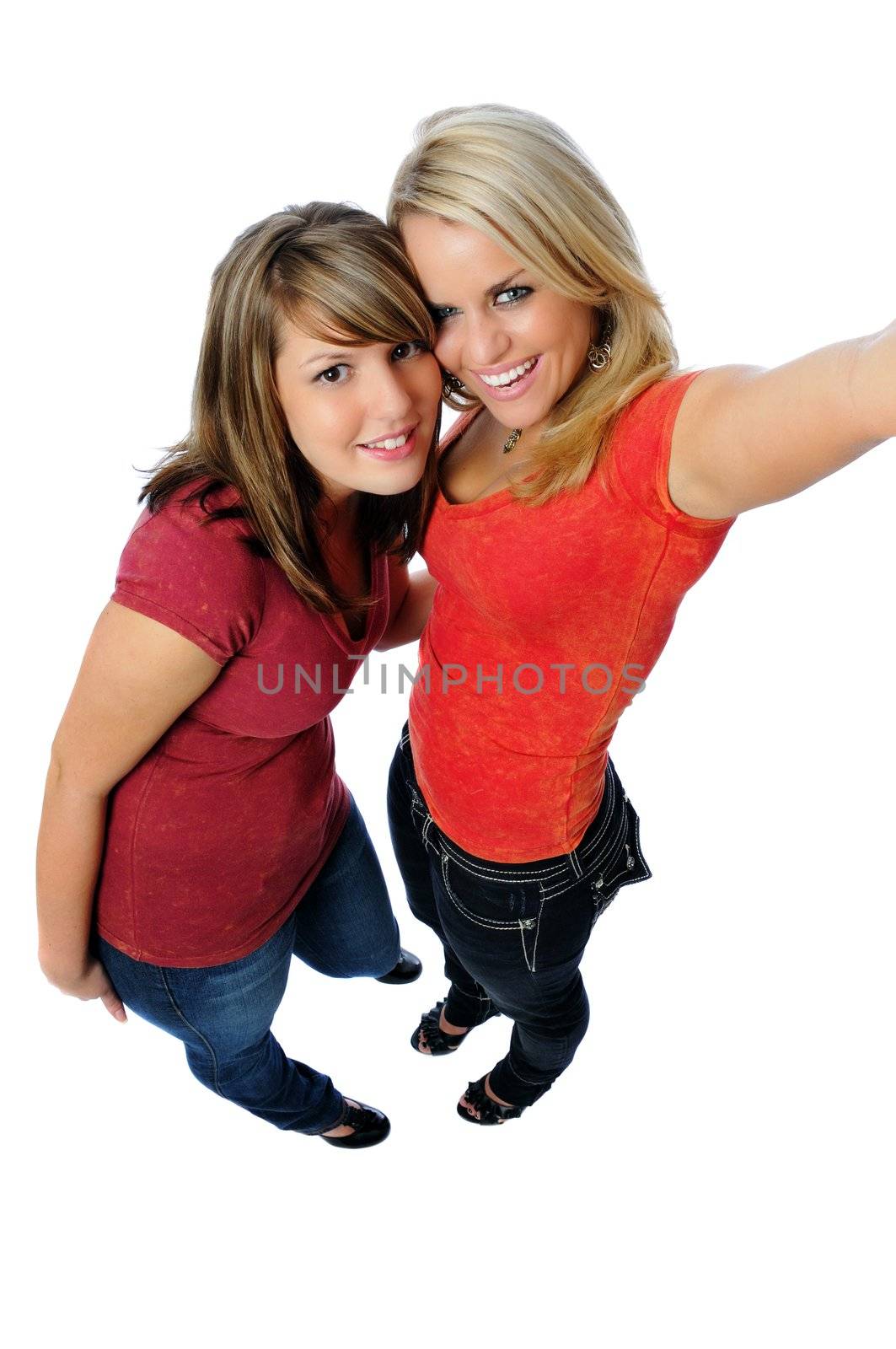 two young ladies having fun and simulating using a camera phone