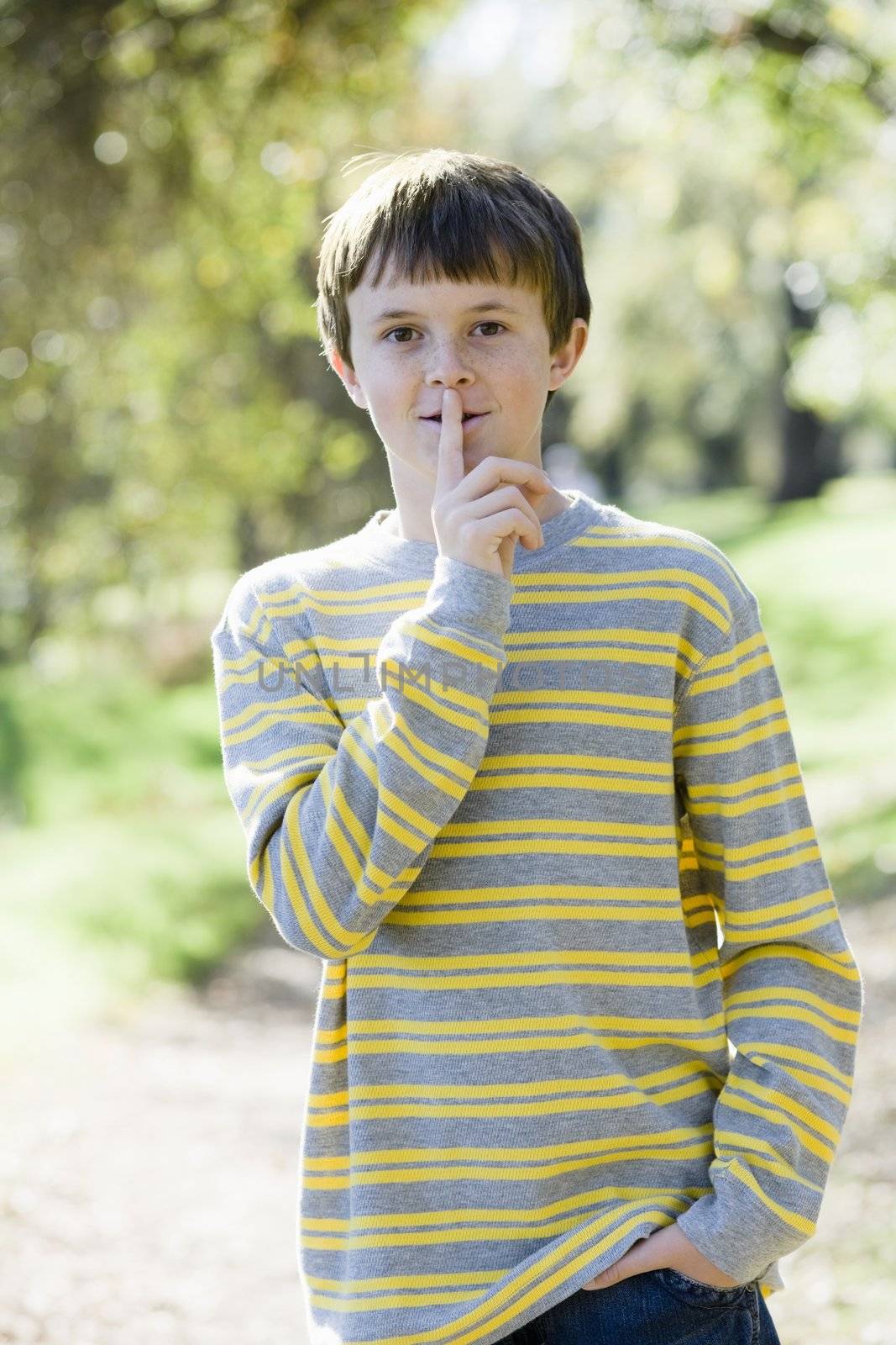 Cute Young Boy Standing Outdoors With Hands in Pockets