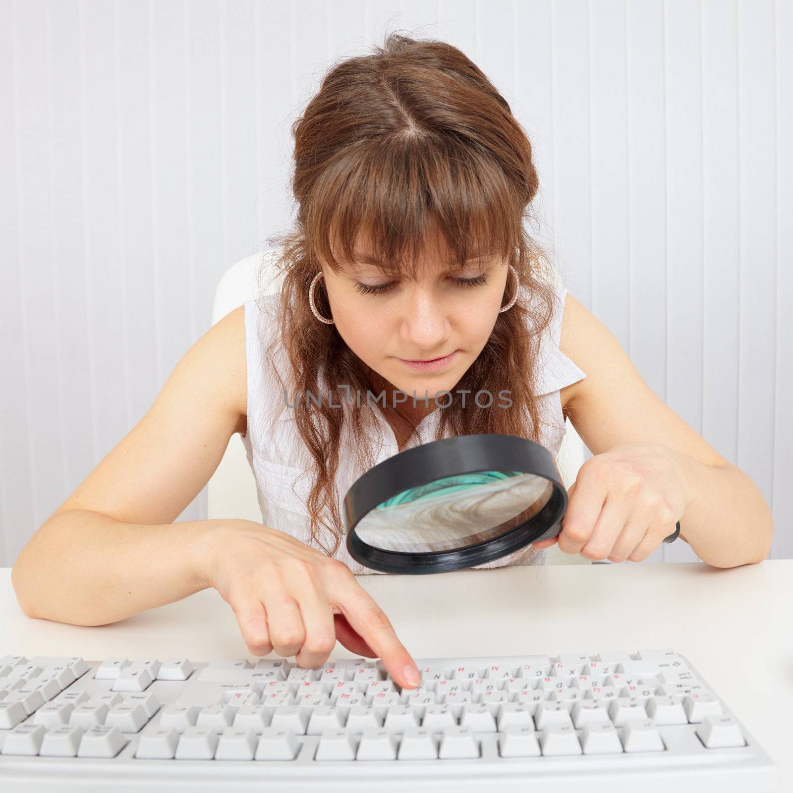 Girl with poor eyesight works with computer keyboard by pzaxe