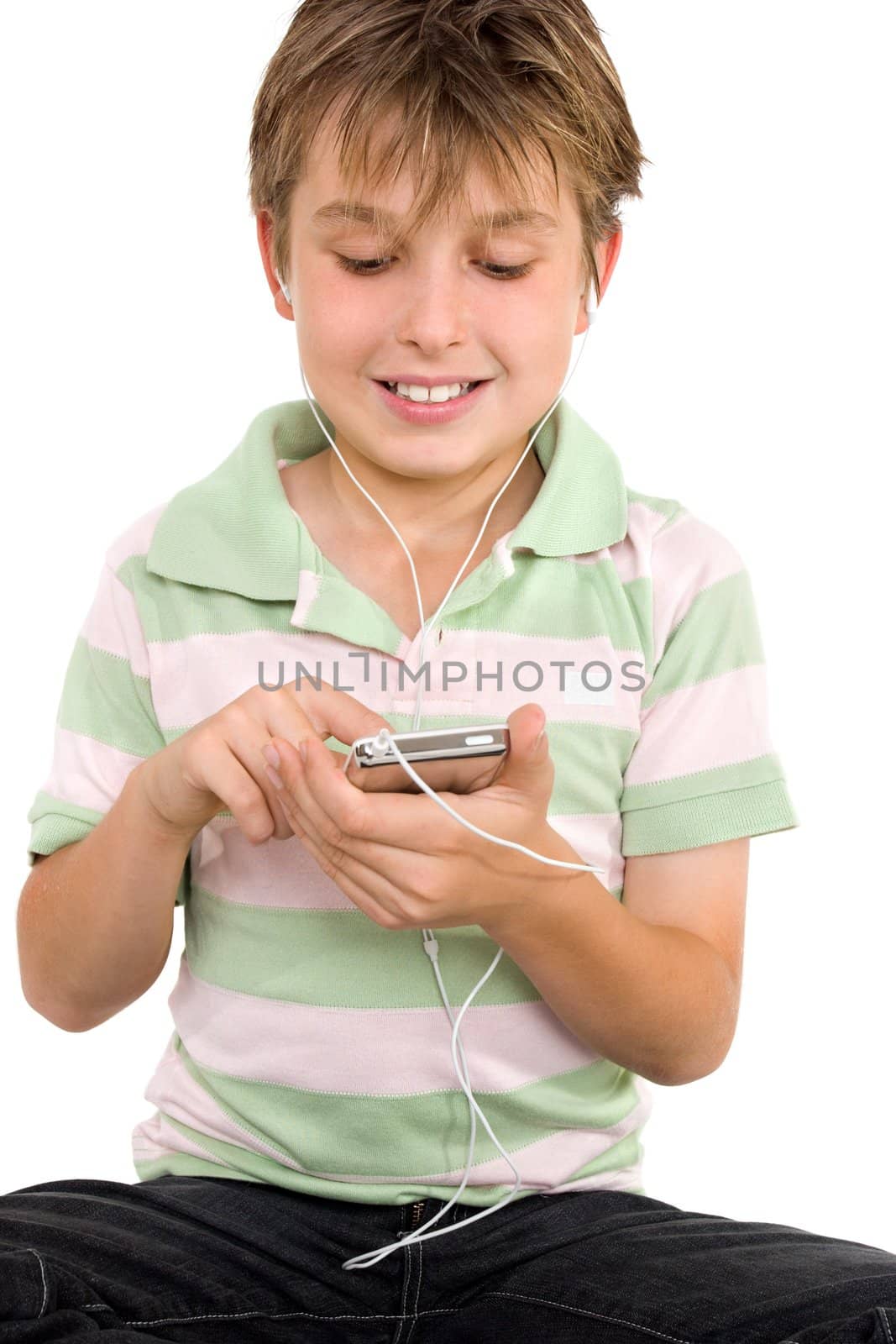 Child sitting down using a digital player.  He is wearing a striped polo shirt and jeans.