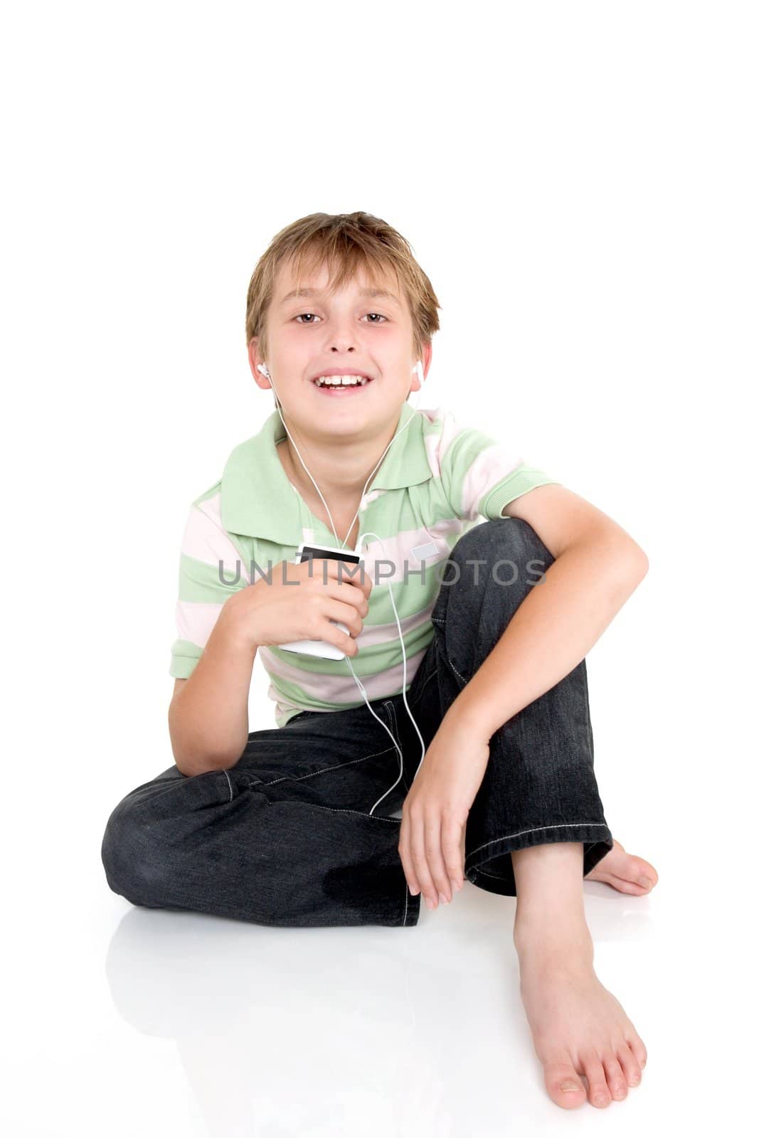 Young happy child sitting casually with an electronic music player.