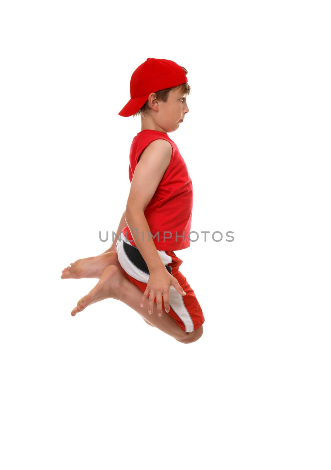 A boy jumps into the air, knees in tight