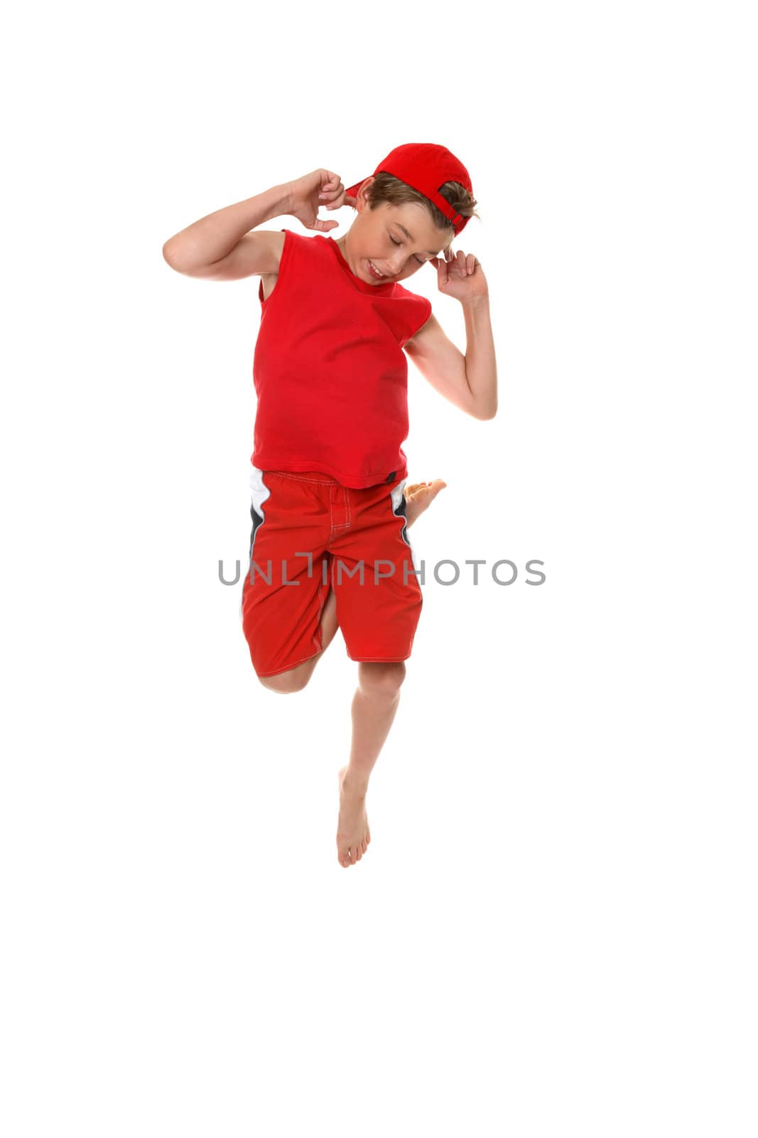 A boy dancing or hopping up and down and making faces.