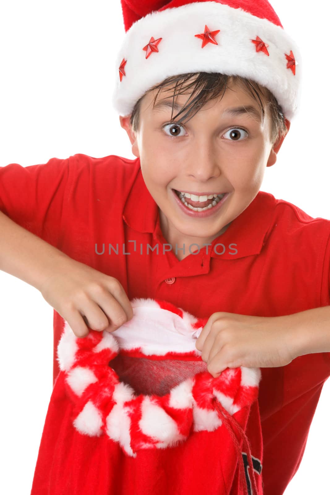 Merry boy holding a red toy sack for presents at Christmas