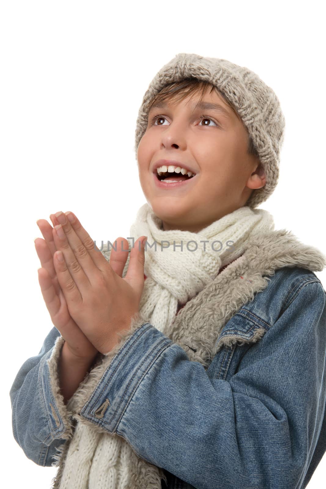 Young boy dressed in winter clothing looking up and smiling