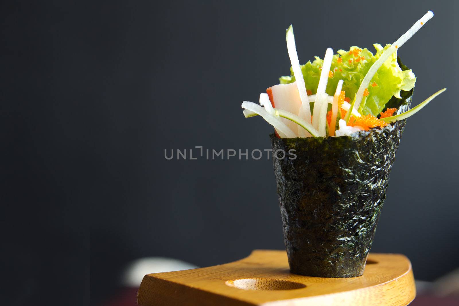 Japanese food, California hand roll hold in a wooden fixture