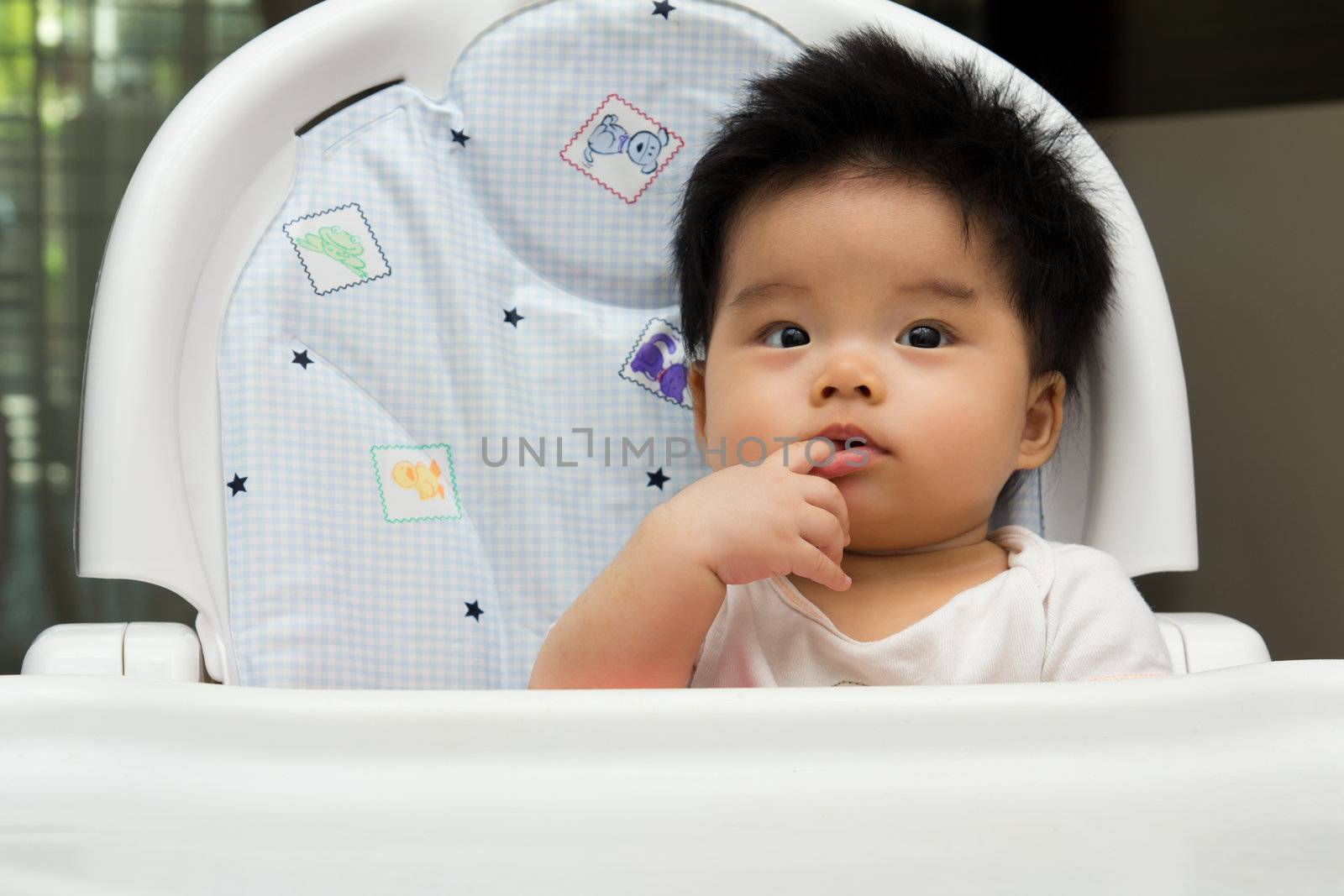 Portrait of a little Asian baby girl sits on a high chair