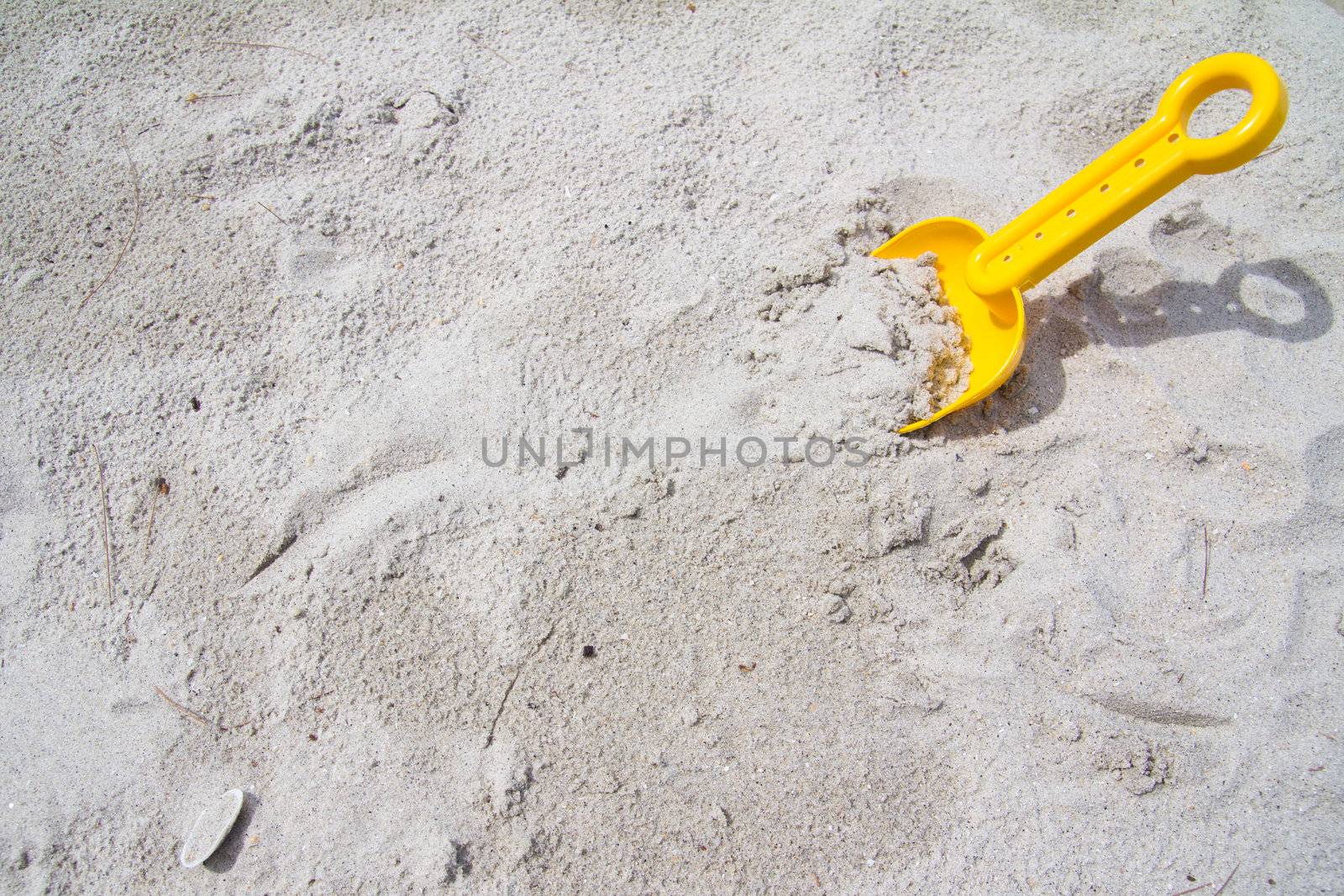 Shovel in the sand and falls off a little bit on the handle. Lots of space on the left hand side for copy