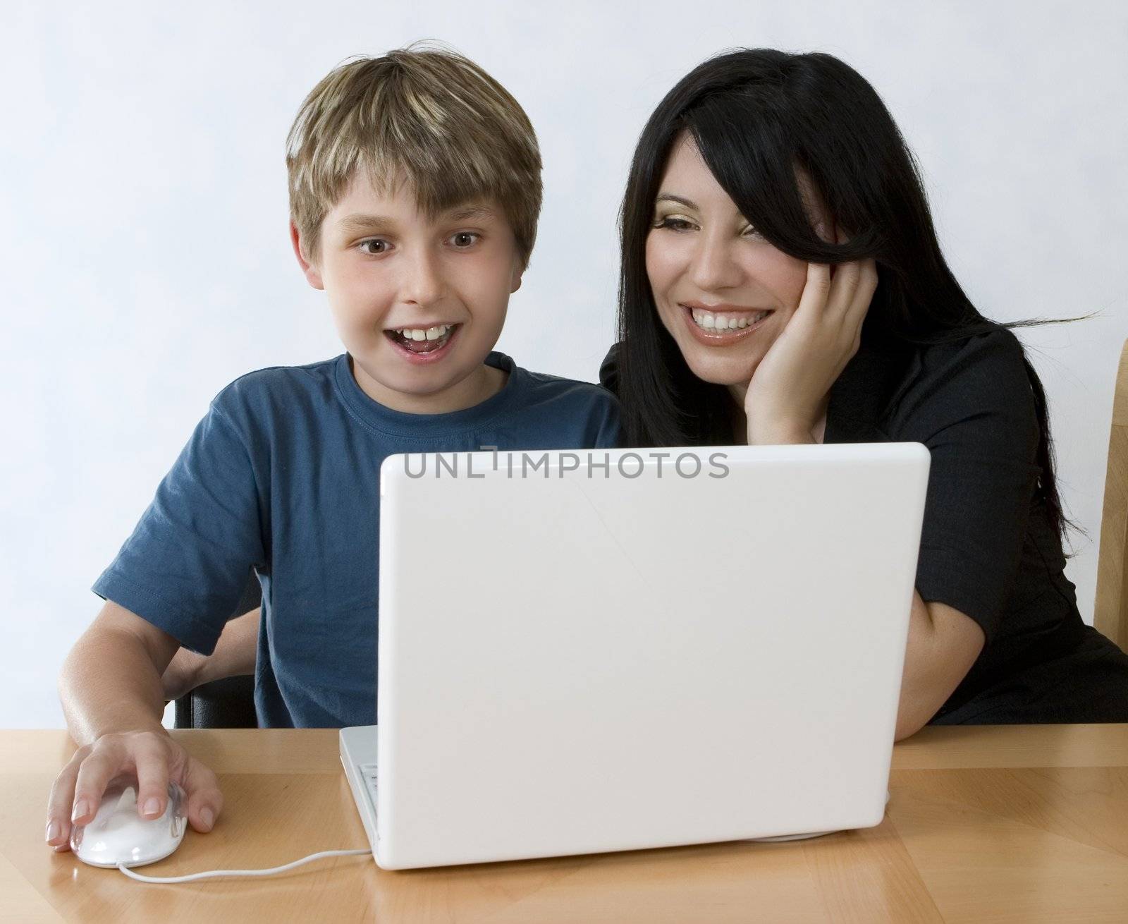 Learning can be fun.   A boy using a laptop computer with expression of joy..