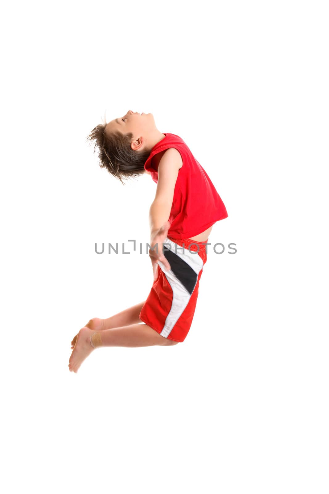 A boy jumps and spreads with arms.  Motion in fingers and feet and parts of the boys hair.