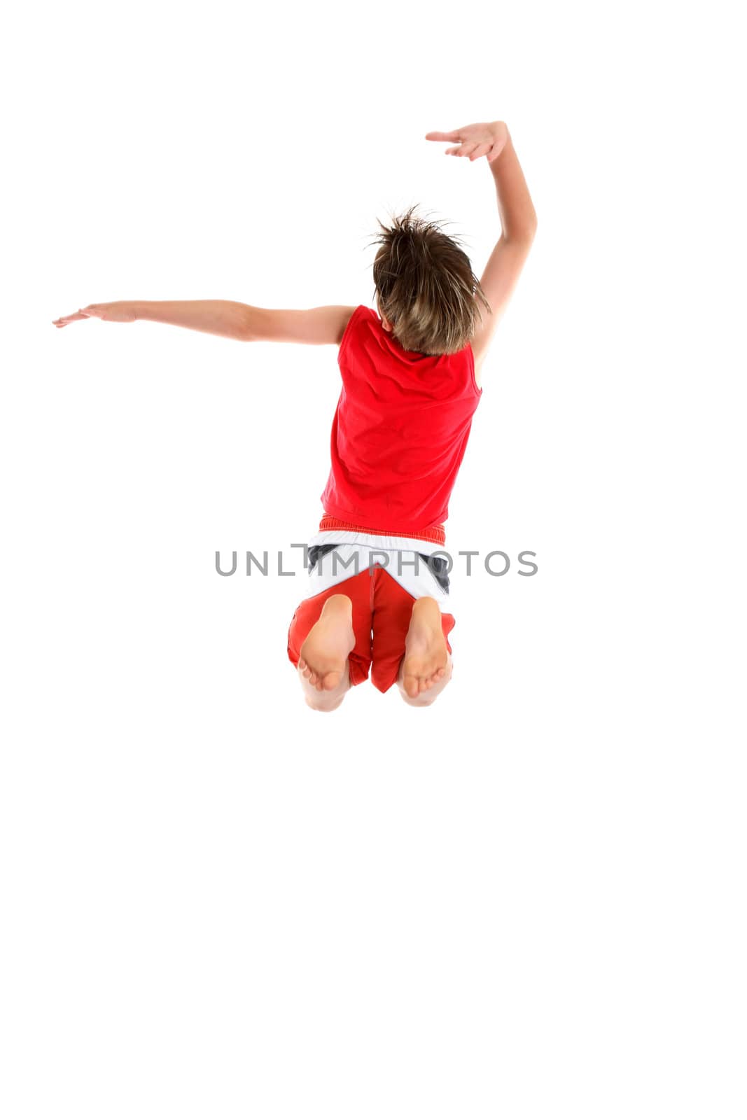 An ecstatic  boy leaps with arms in a grande pose (second and third position)