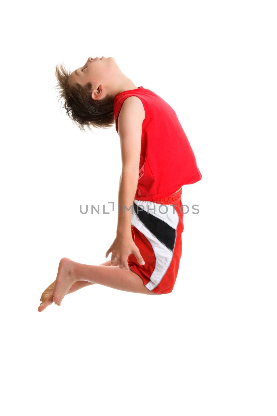 An energetic  boy jumps high and arches head back.  Some motion in hair.