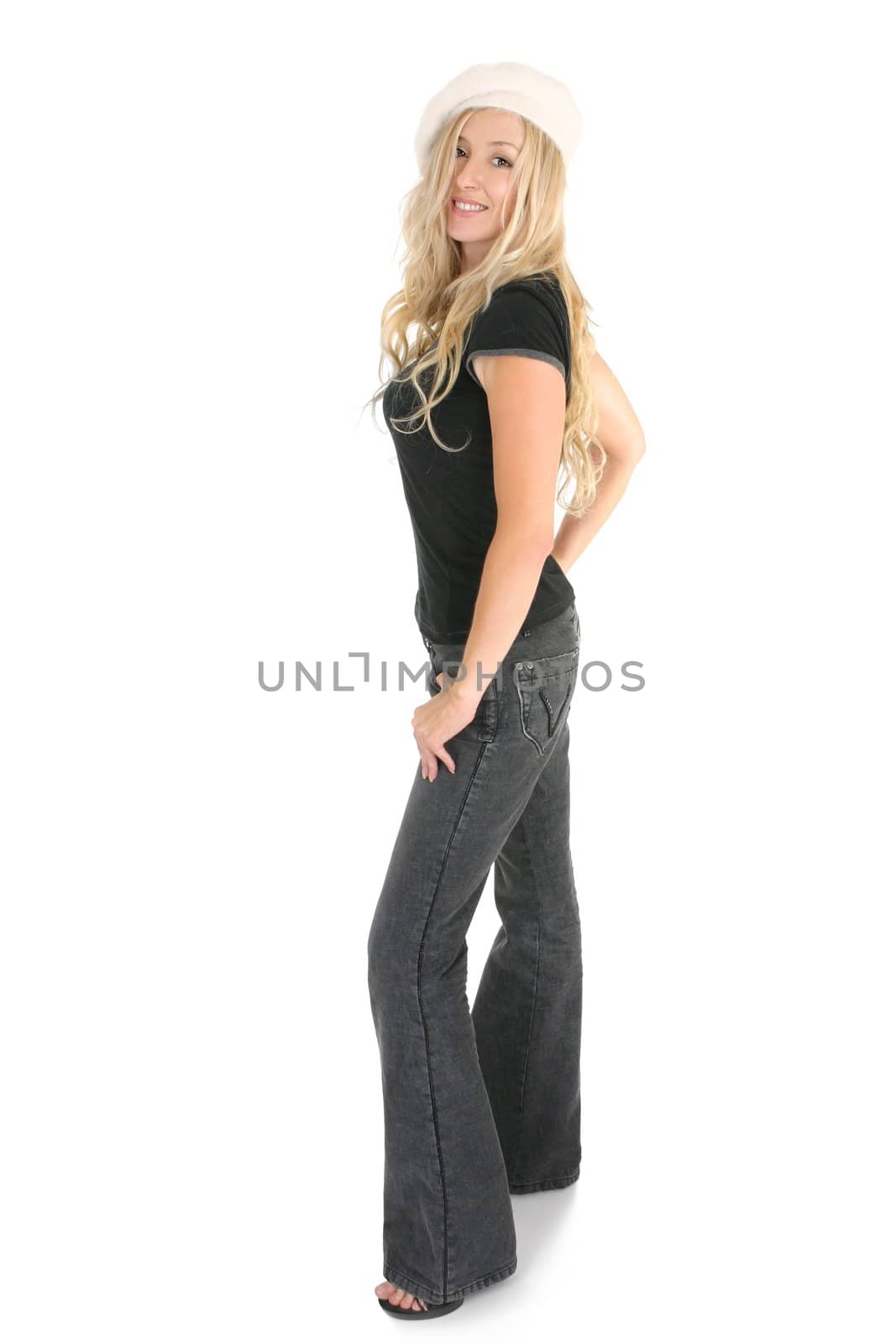 Casual blonde female dressed in charcoal bootleg jeans with leather trim on side seams and pocket with a casual t-shirt, standing in high heels and smiling in a friendly manner.