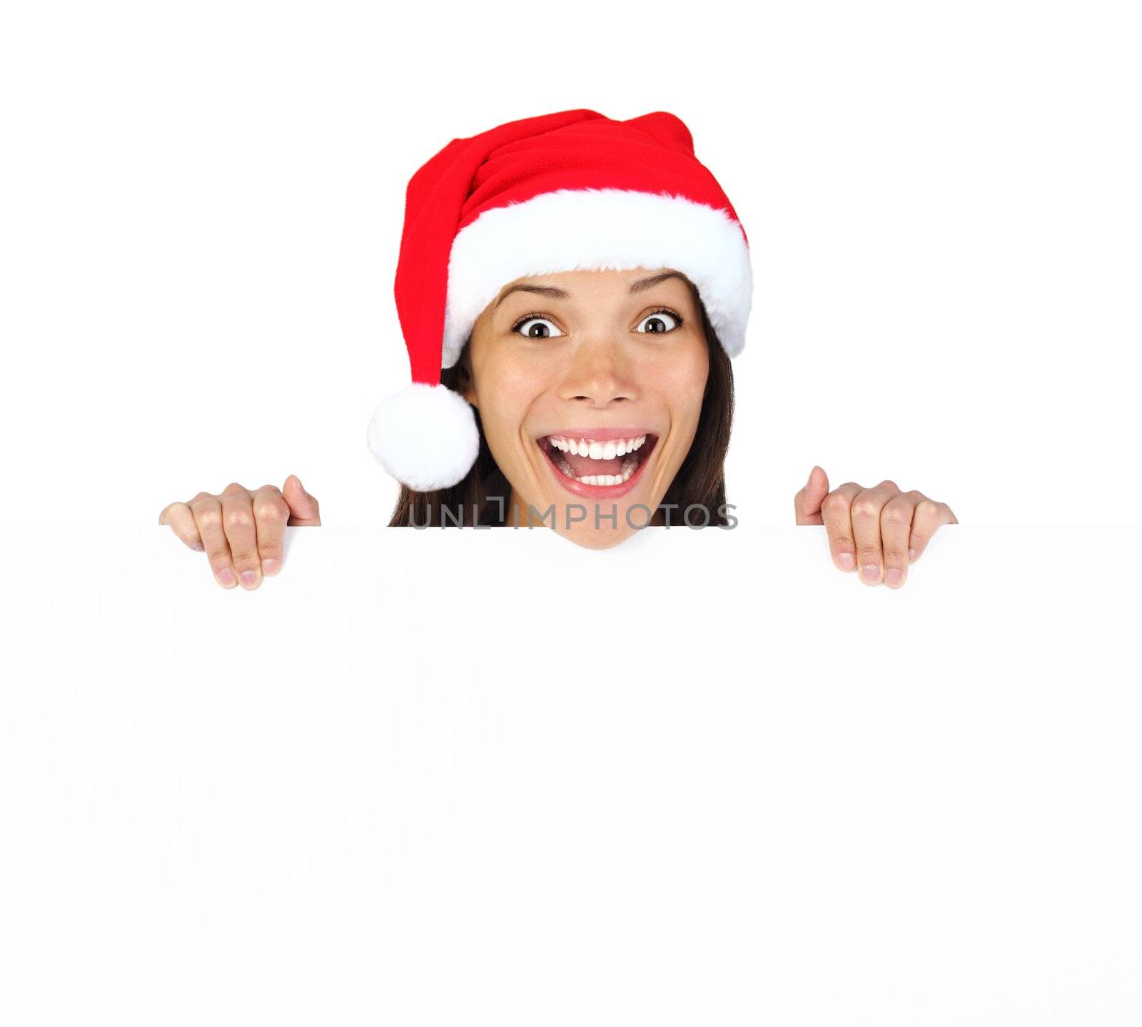 Christmas woman with billboard sign. Very beautiful mixed race asian / caucasian woman standing behind billboard looking happy and surprised at camera with funny expression. Isolated on white background.