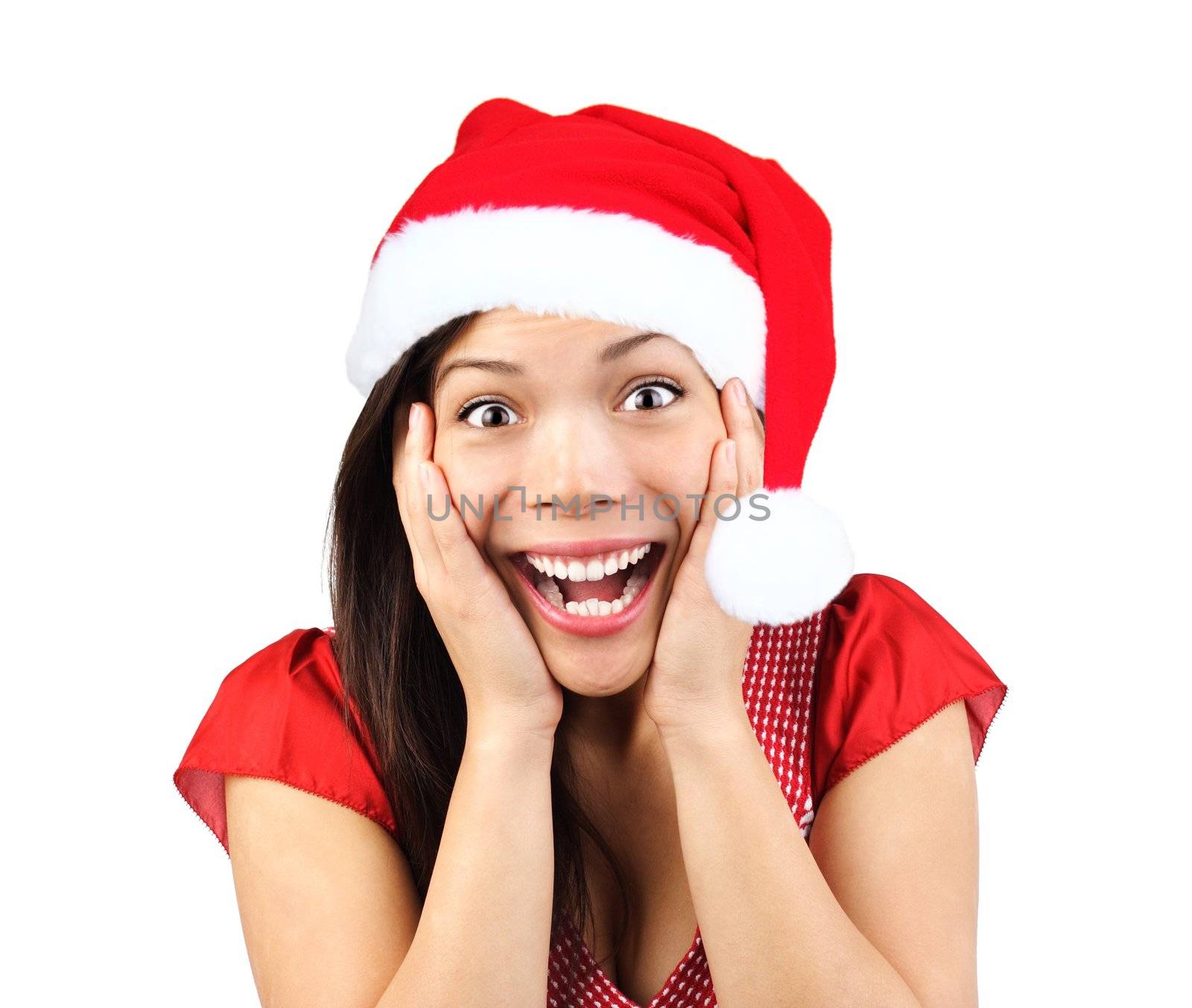  Christmas girl very excited and surprised holding her head. Beautiful mixed asian / caucasian model. Isolated on seamless white background.