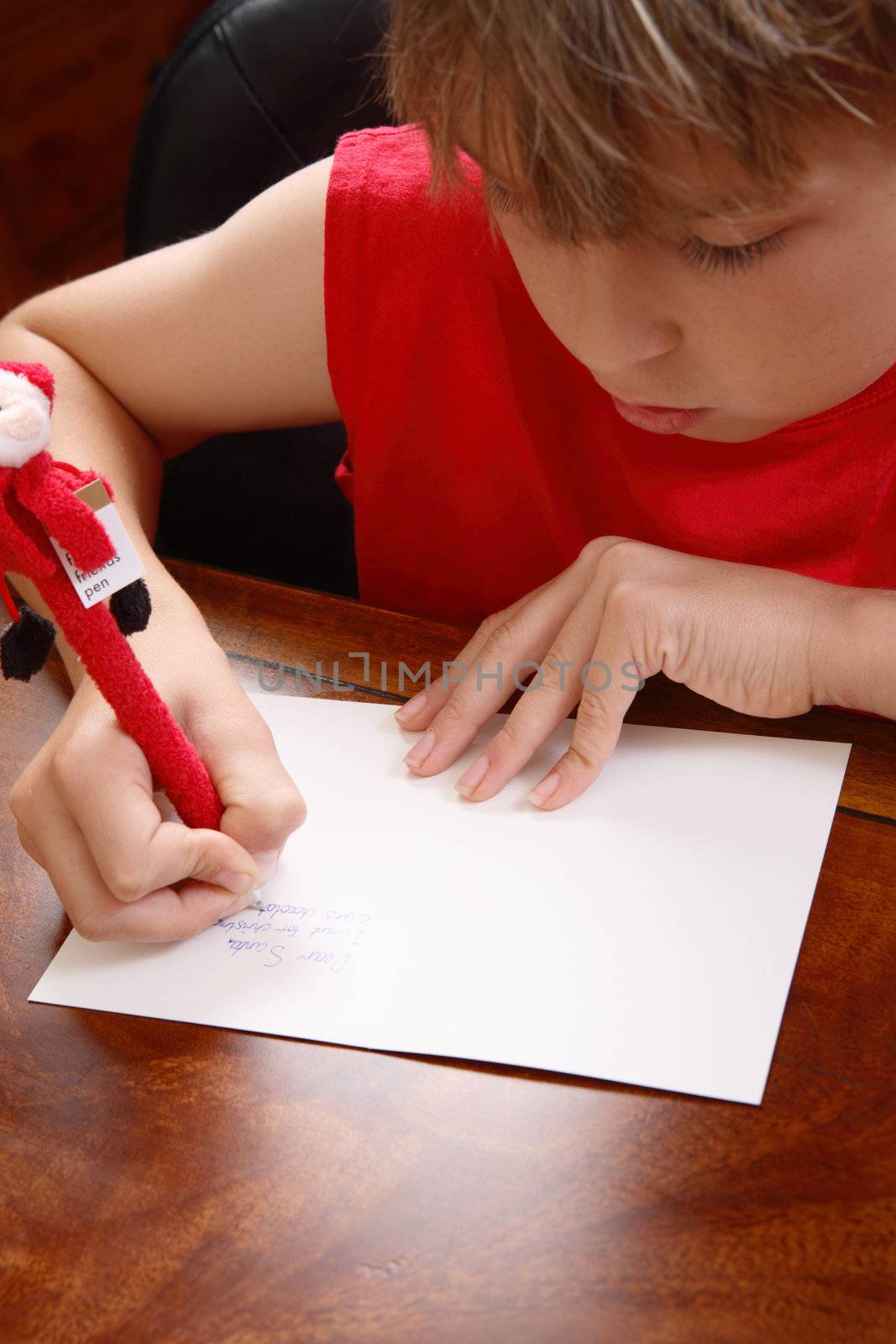 A child writing a letter to santa.  Focus to hands