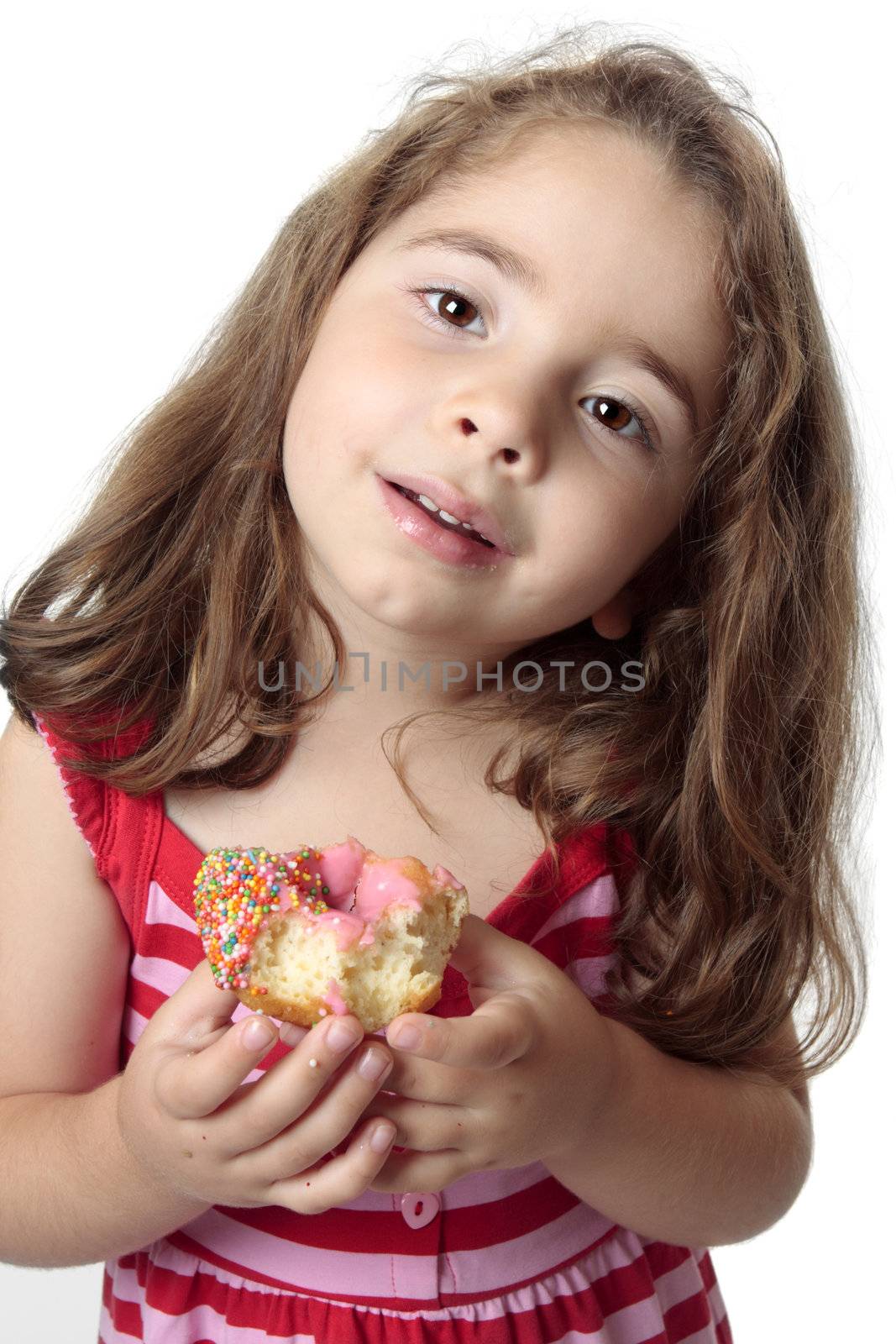 Small child eating a pink iced  doughnut.  She has messy fingers.
