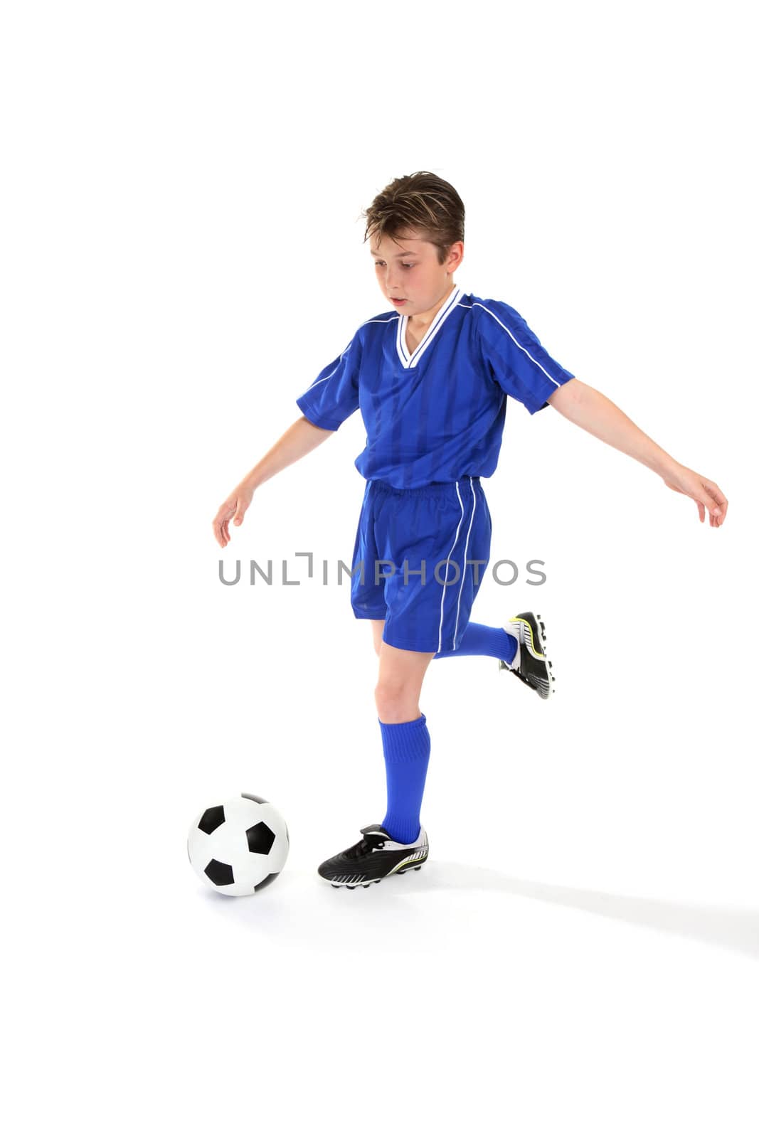 A boy kicks a soccer ball. Some slight motion