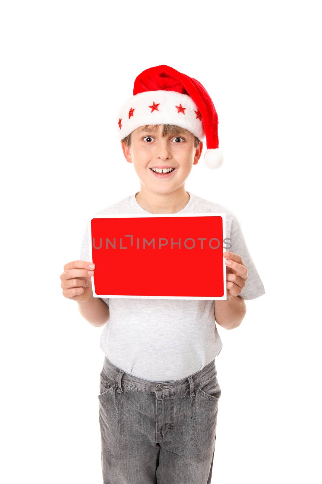 A child dressed in grey jeans and grey marle t-shirt and wearing a red santa hat holding a small red and white blank sign ready for your message or graphics.